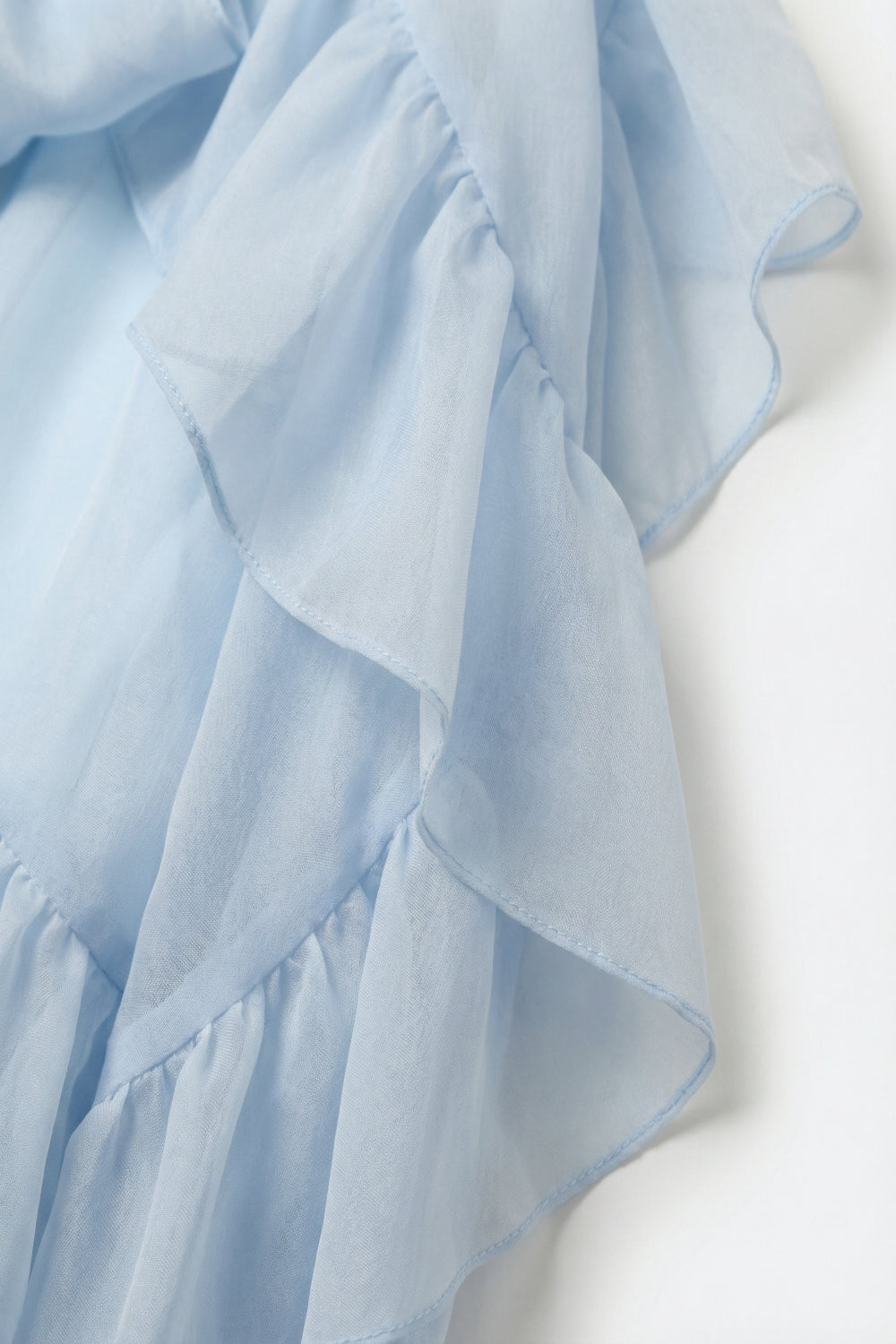 Blusa leggera azzurra con volant trasparenti in tessuto di chiffon