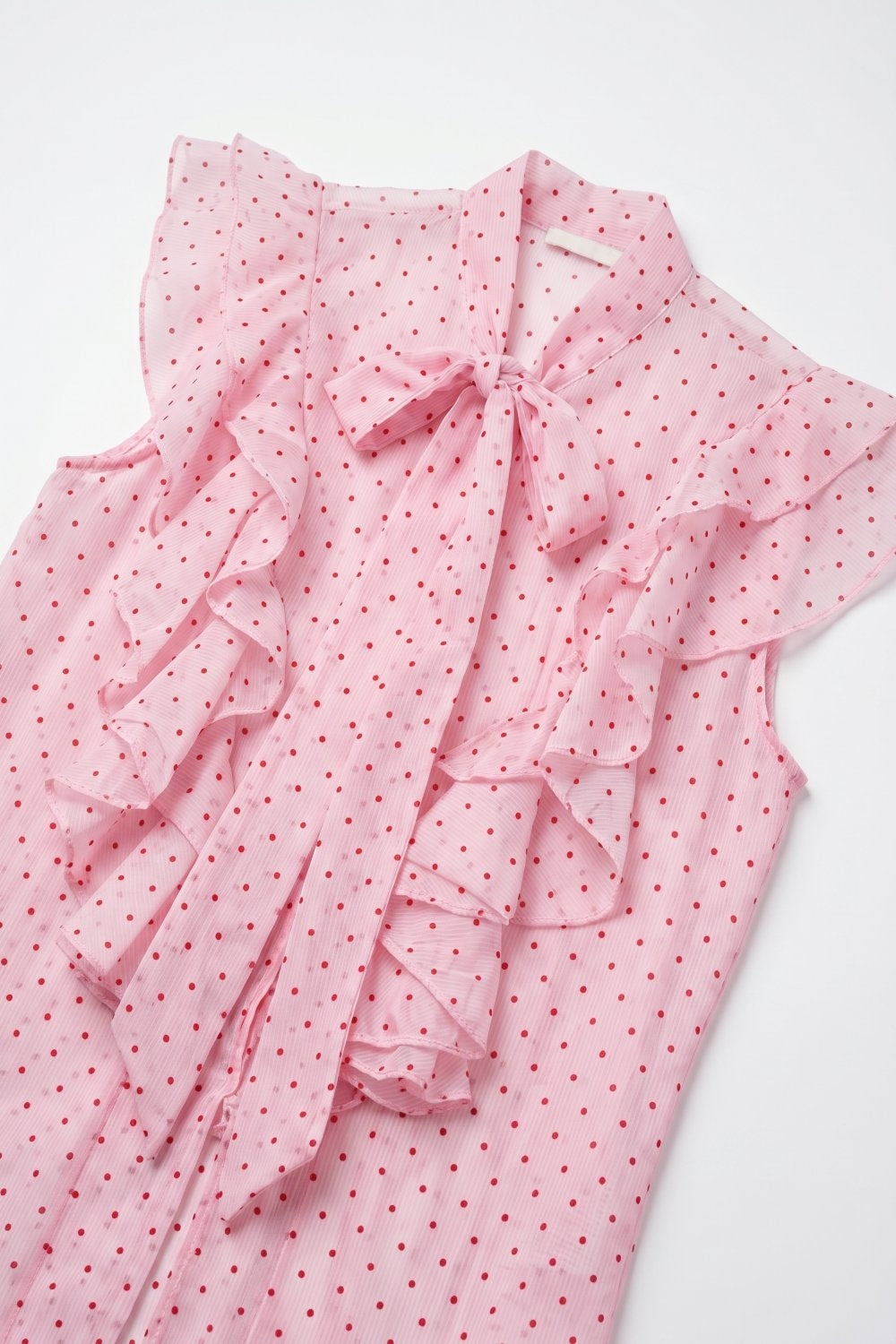 Blusa smanicata con fiocco e volant in chiffon a pois rosa chiaro
