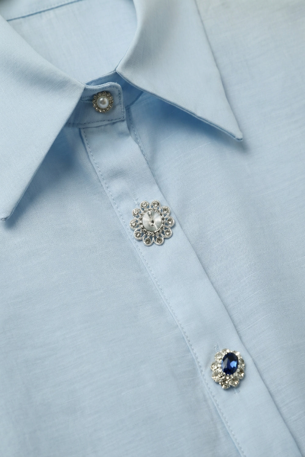 Camicia a maniche lunghe in raso azzurro con bottoni e due bottoni sui polsini