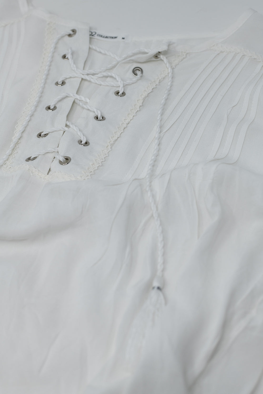 Camicia bianca con nappe e chiusura a cravatta incrociata