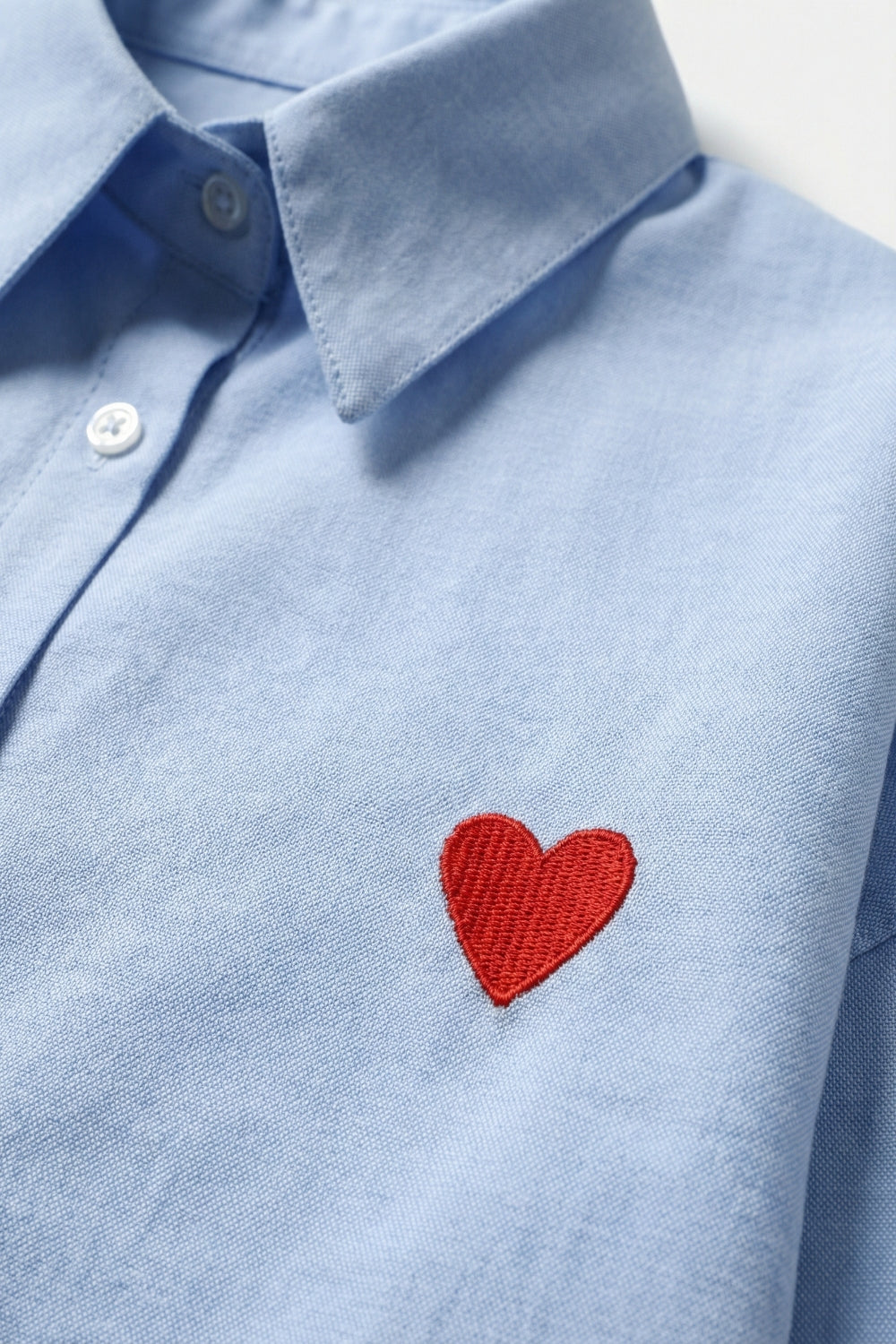 Camicia in cotone Oxford blu con dettaglio cuore rosso ricamato