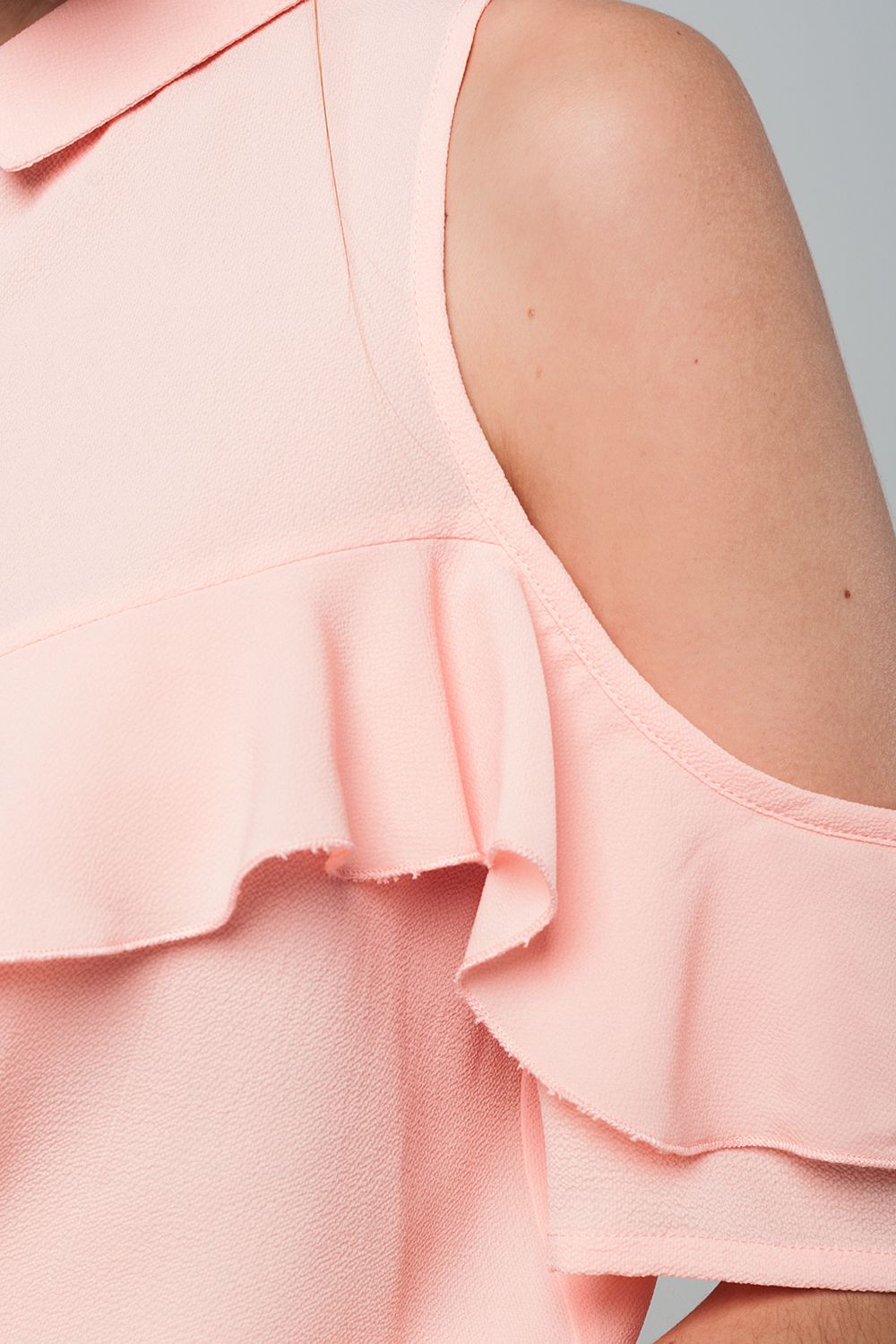Camicia rosa con le spalle scoperte e volant