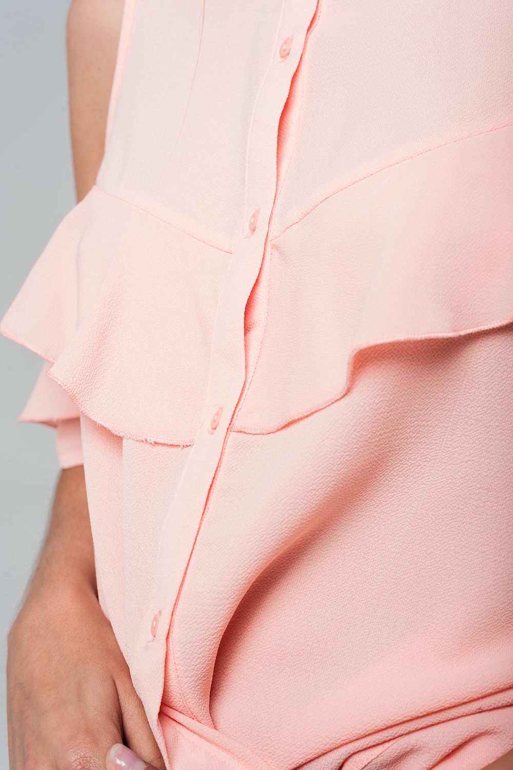 Camicia rosa con le spalle scoperte e volant