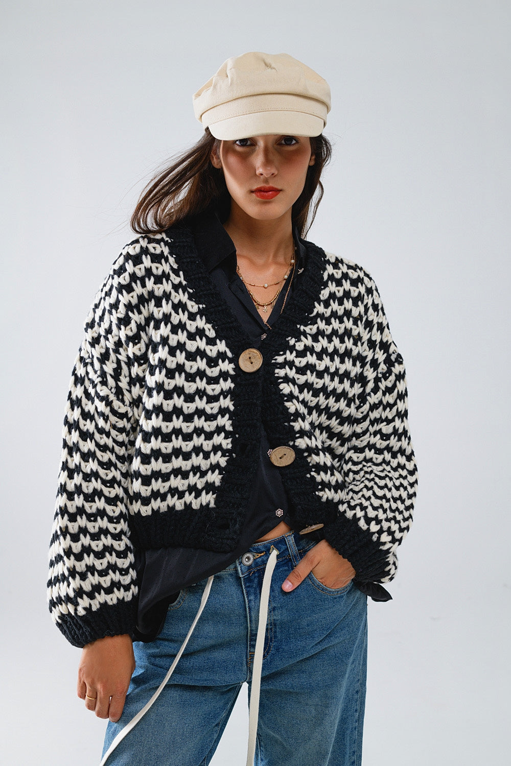 Cardigan a scacchi con grossi bottoni di legno in bianco e nero