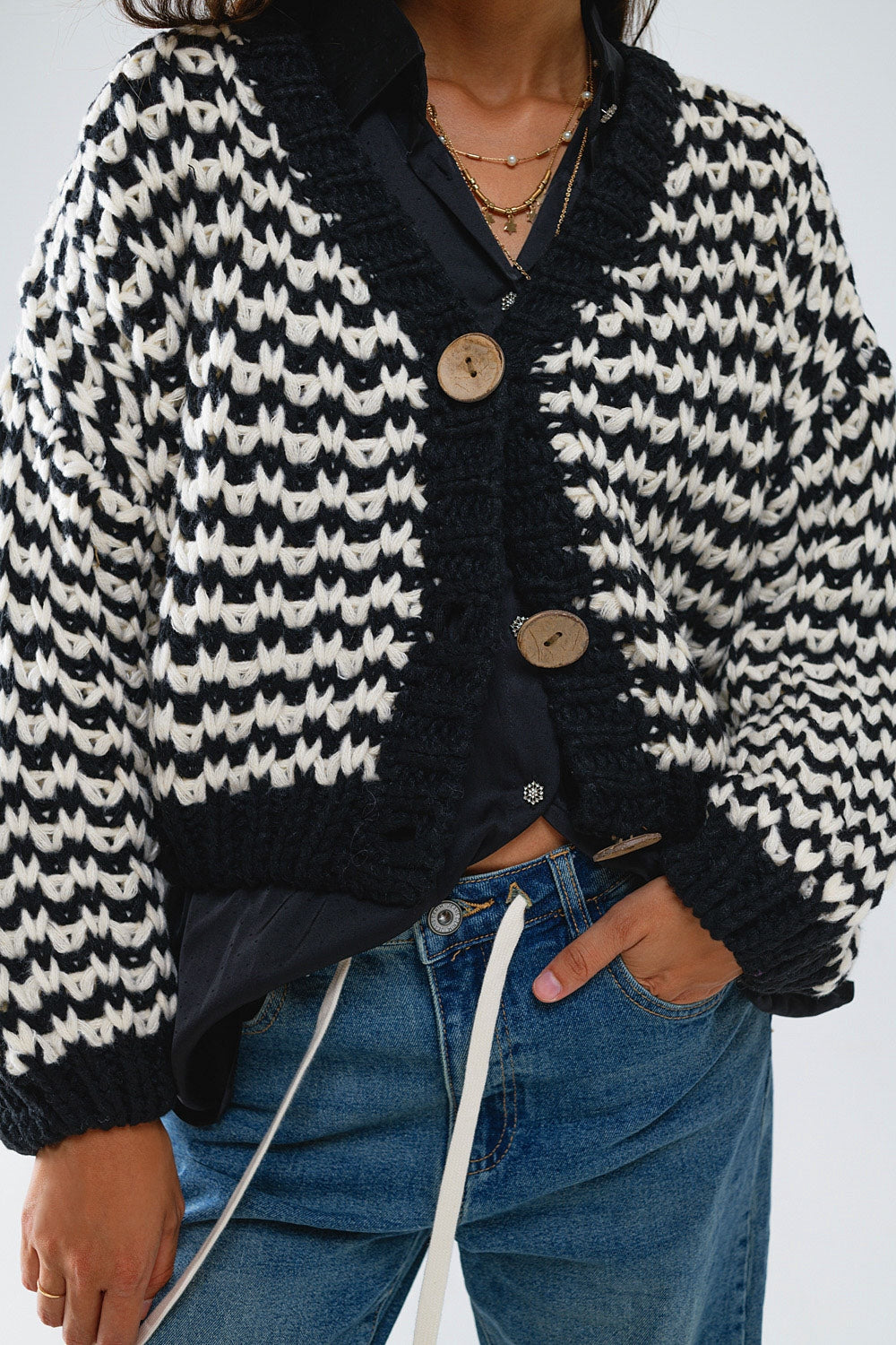 Cardigan a scacchi con grossi bottoni di legno in bianco e nero