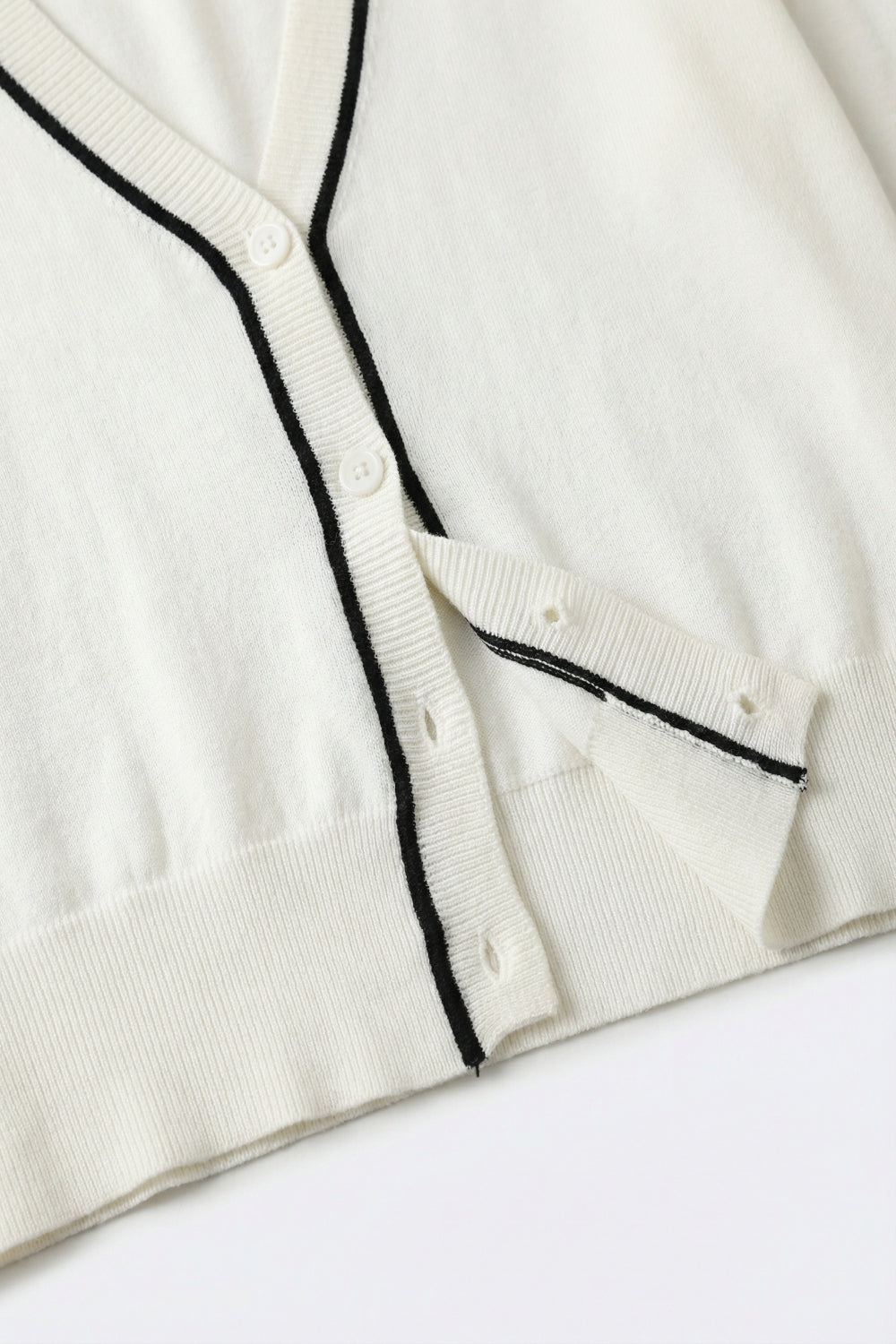 Cardigan bianco a maglia fine con rifiniture a contrasto in nero