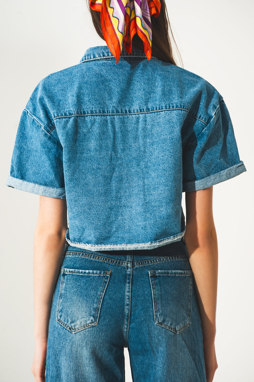 giacca cropped in denim con lavaggio blu medio