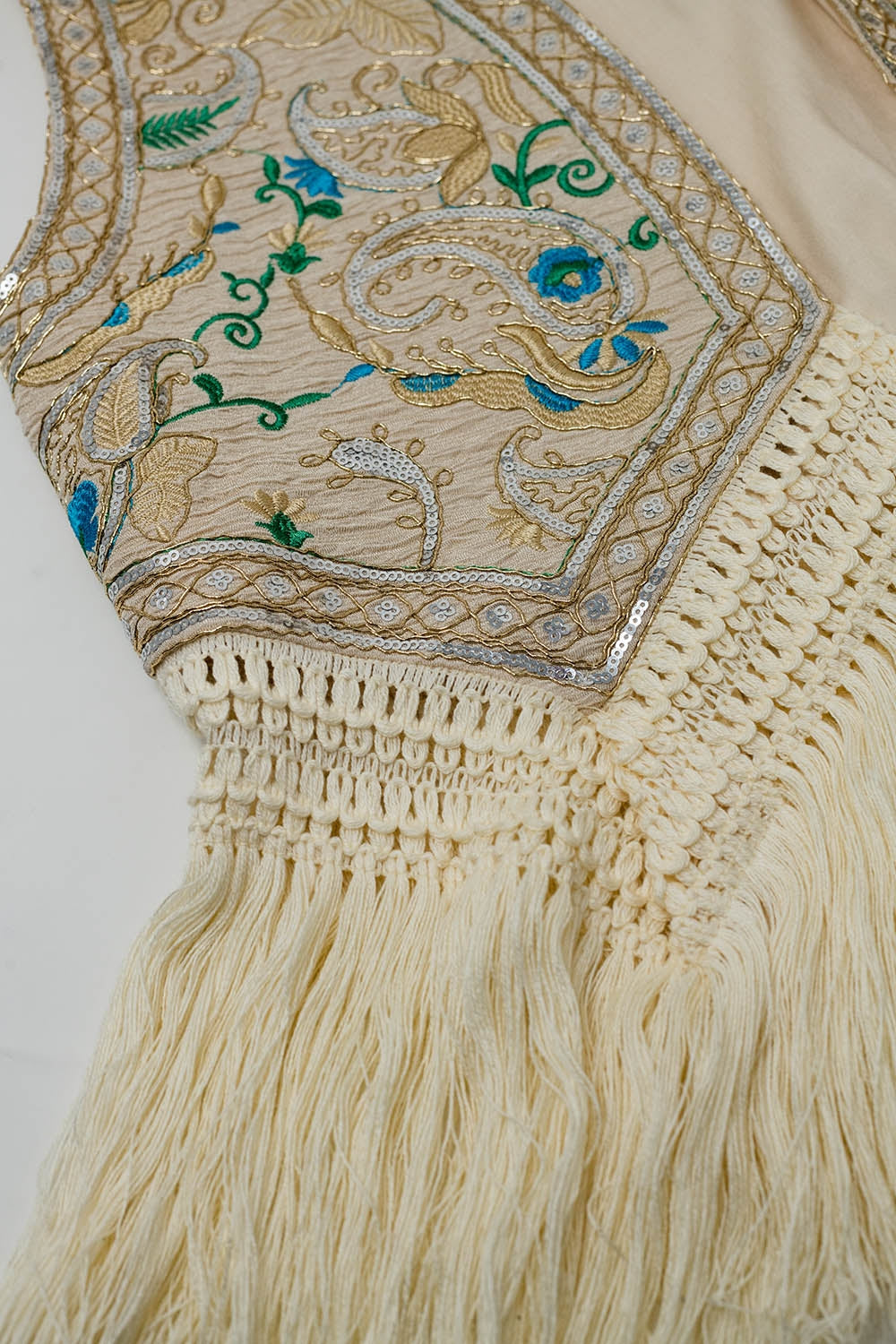 Gilet cropped con dettagli floreali e frange in basso