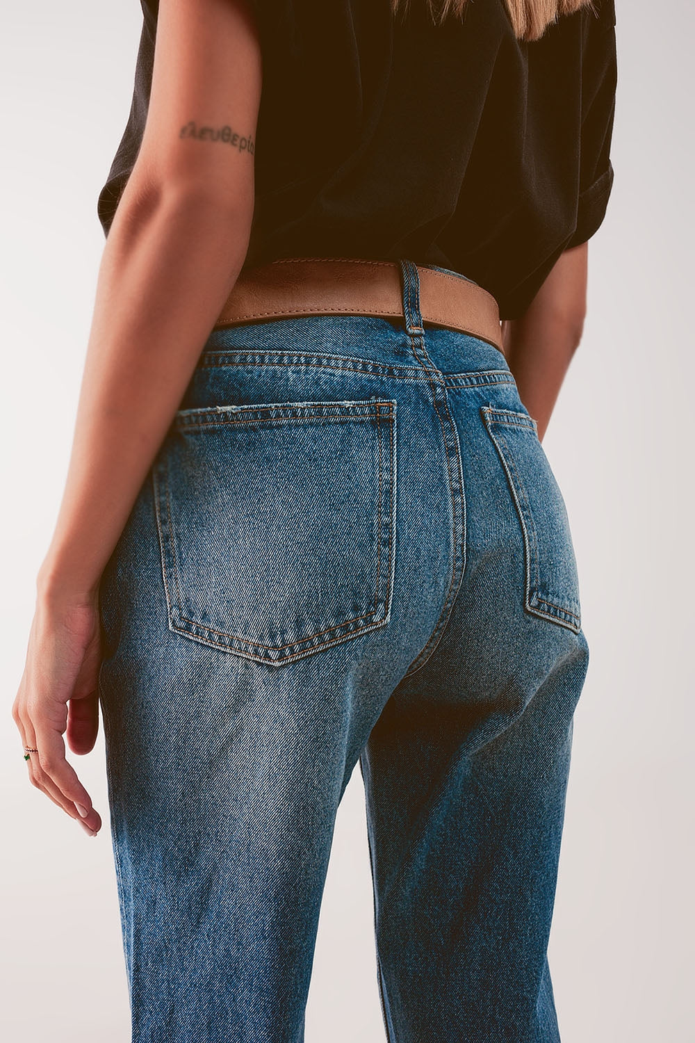 Jeans a vita alta con strappo in blu medio