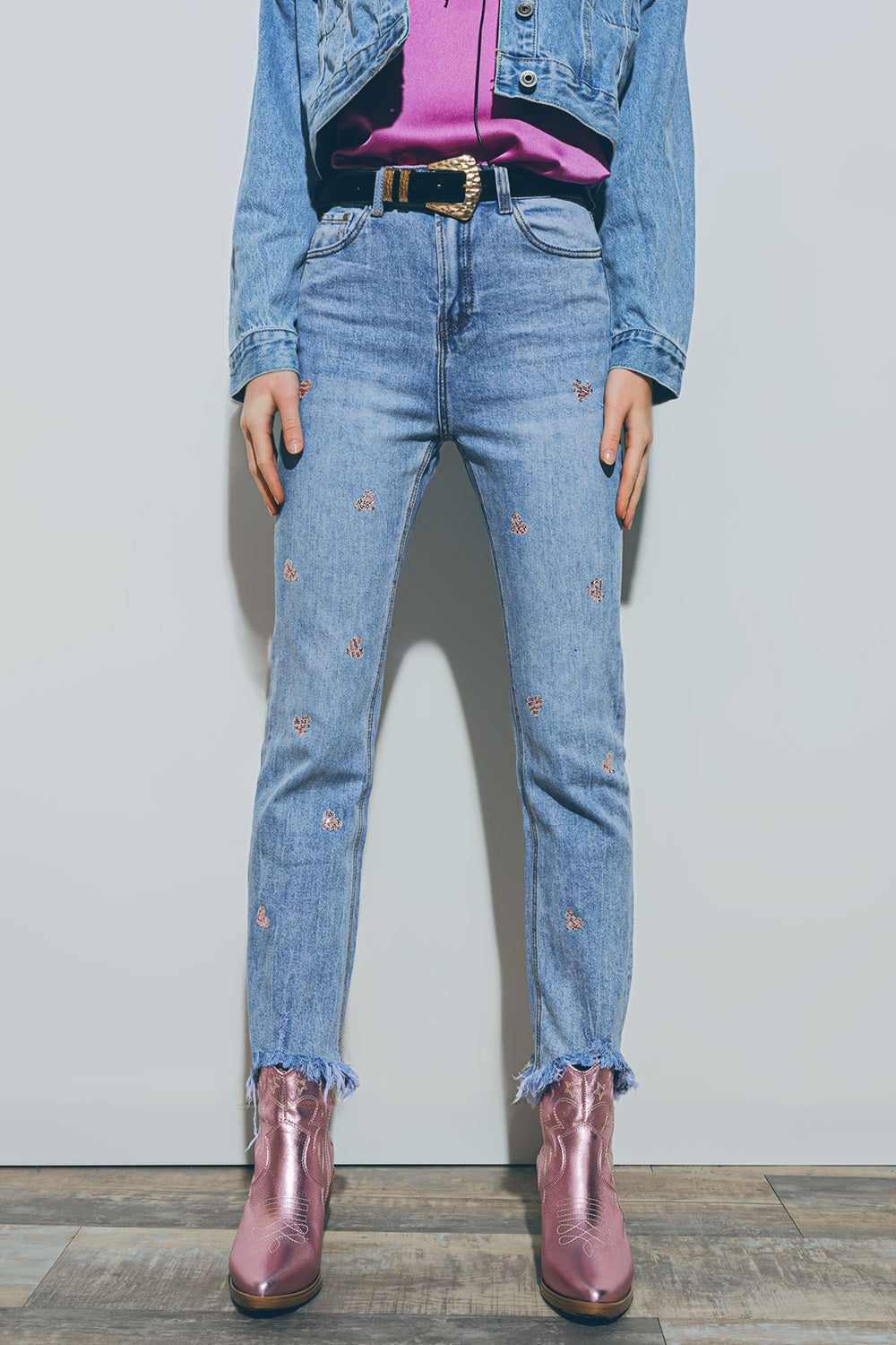 Jeans con cuore impreziosito e orlo strappato in lavaggio medio
