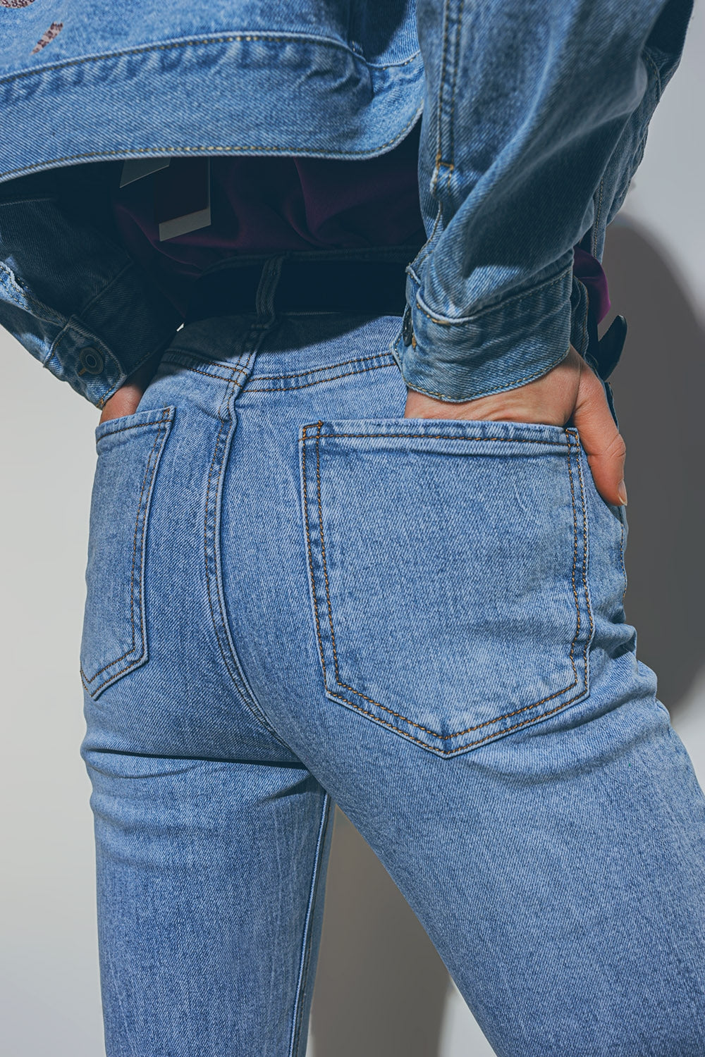 Jeans con cuore impreziosito e orlo strappato in lavaggio medio