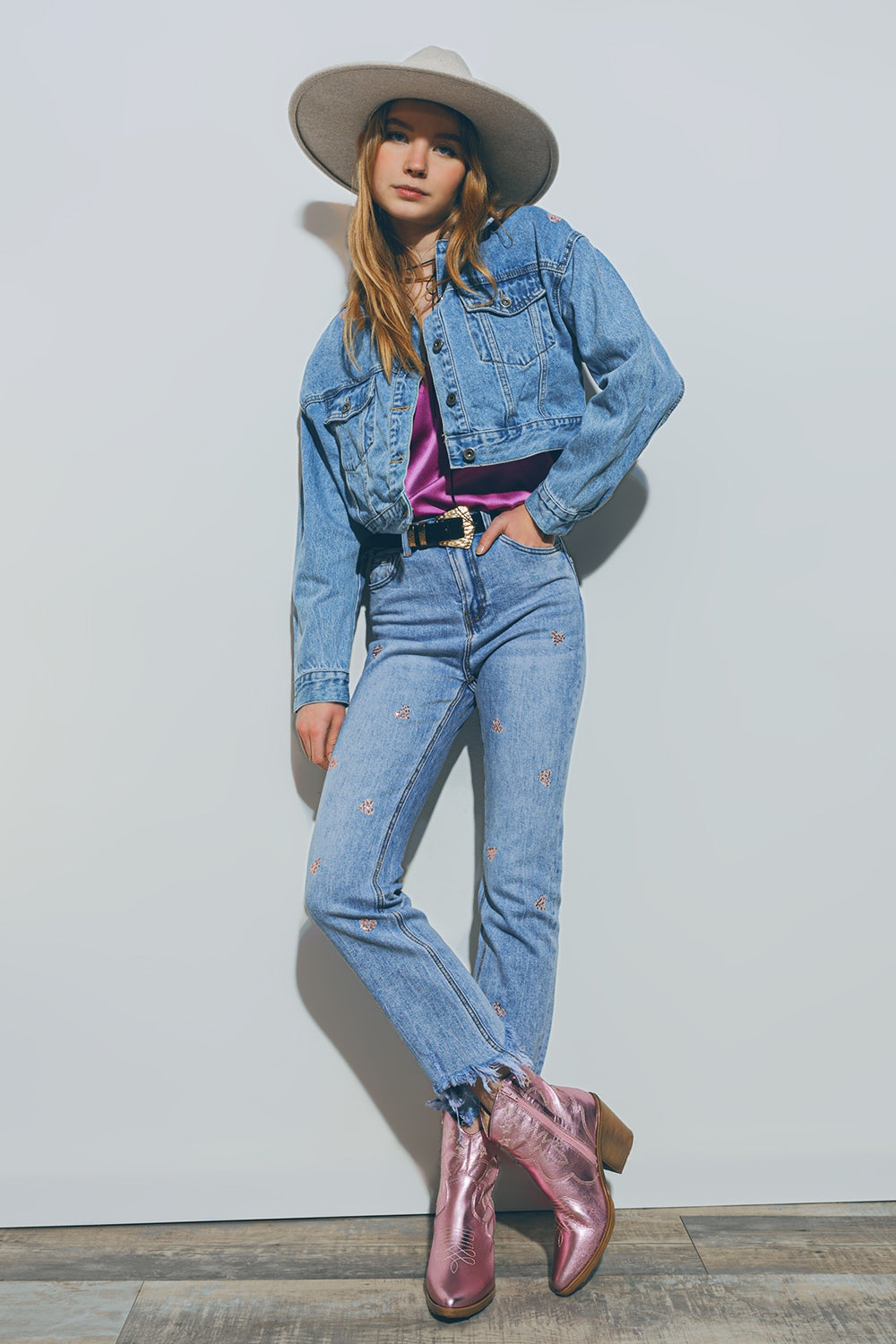 Jeans con cuore impreziosito e orlo strappato in lavaggio medio