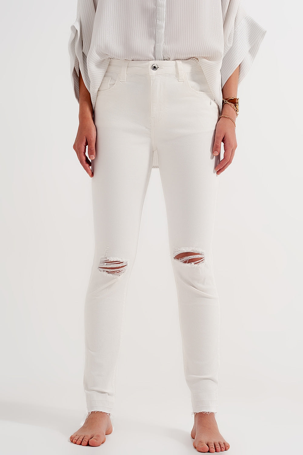 Jeans crema con strappi e fondo sfrangiato