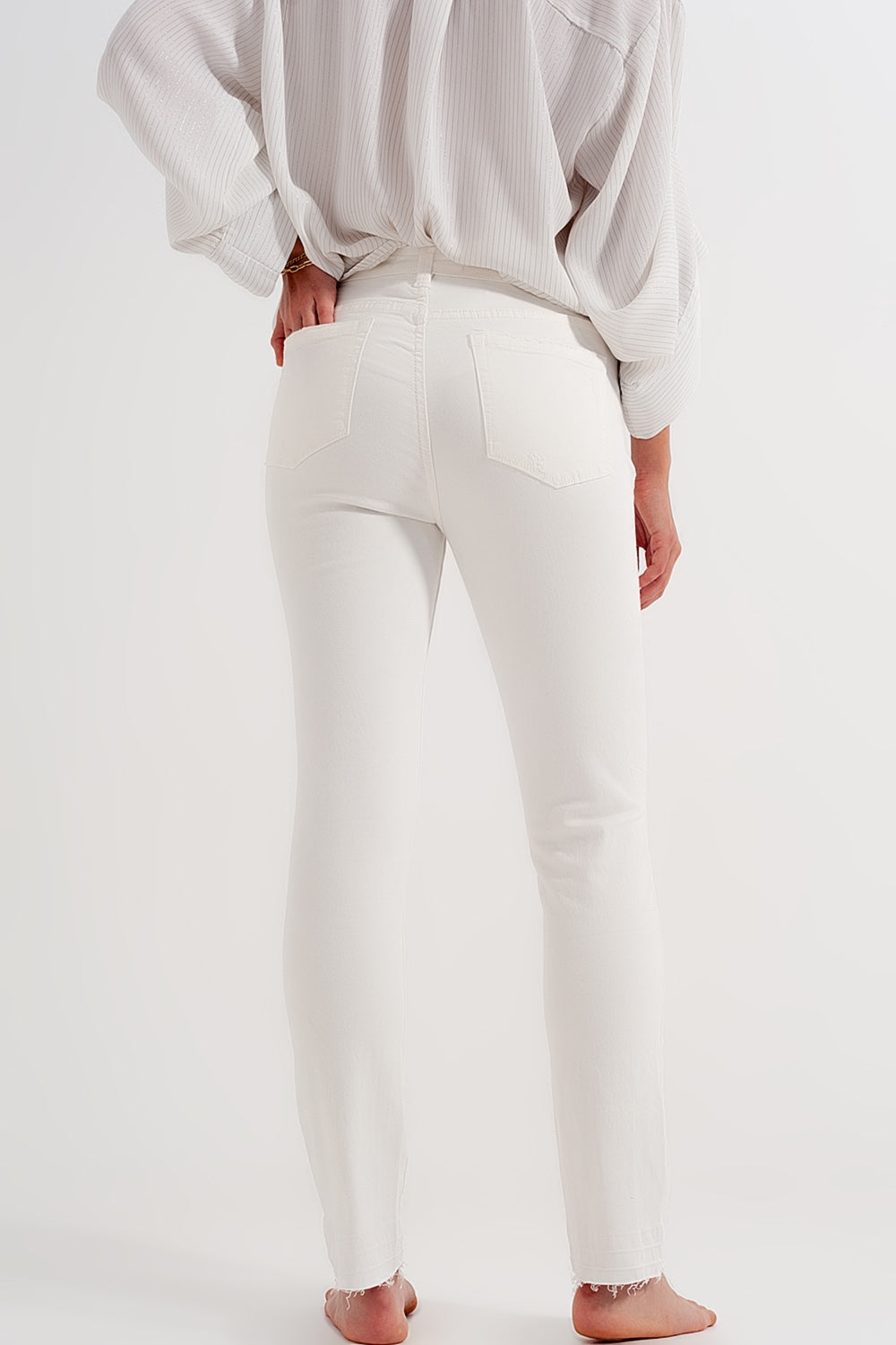 Jeans crema con strappi e fondo sfrangiato