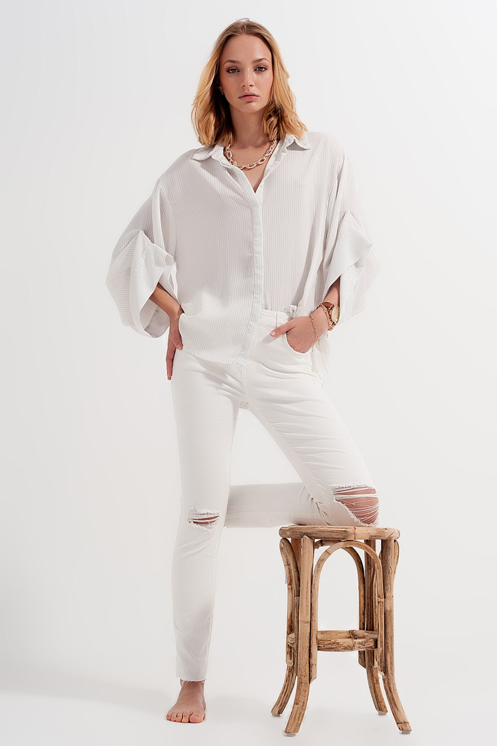 Jeans crema con strappi e fondo sfrangiato