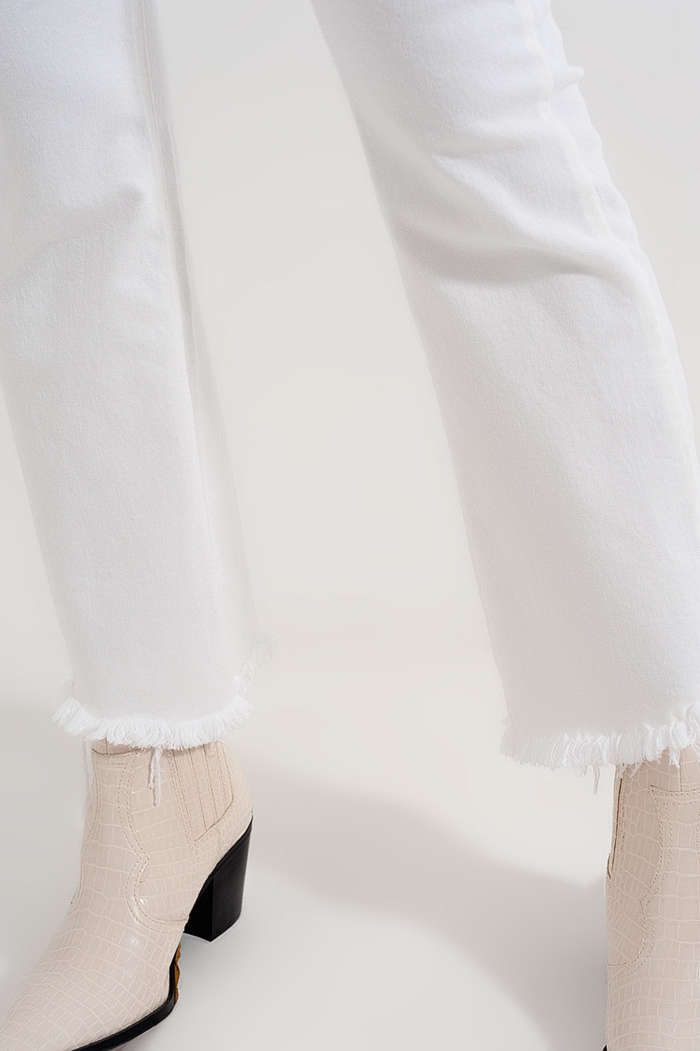Jeans cropped a zampa crema con orlo grezzo