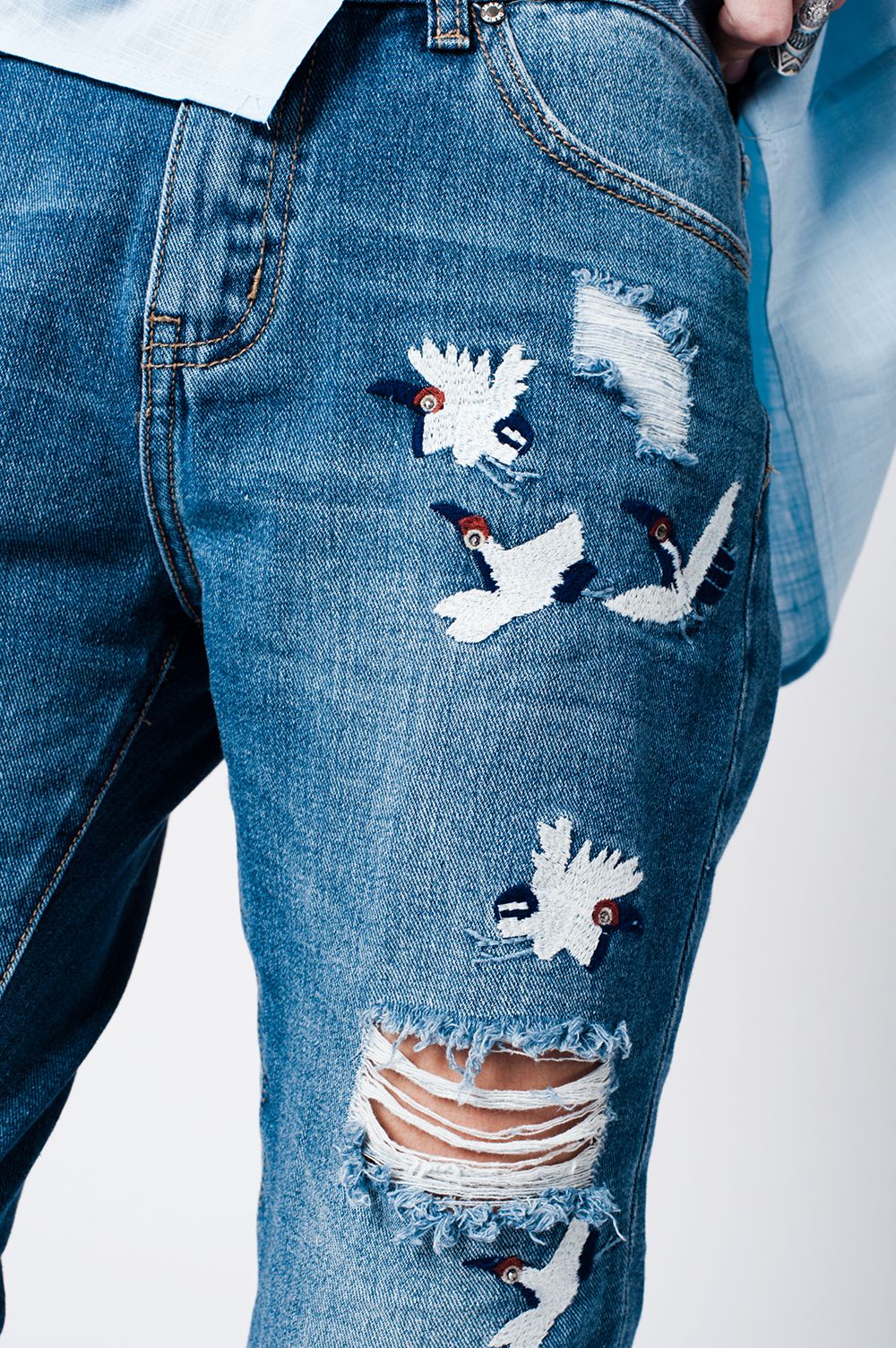 jeans mom slavati con strappi e uccelli ricamati
