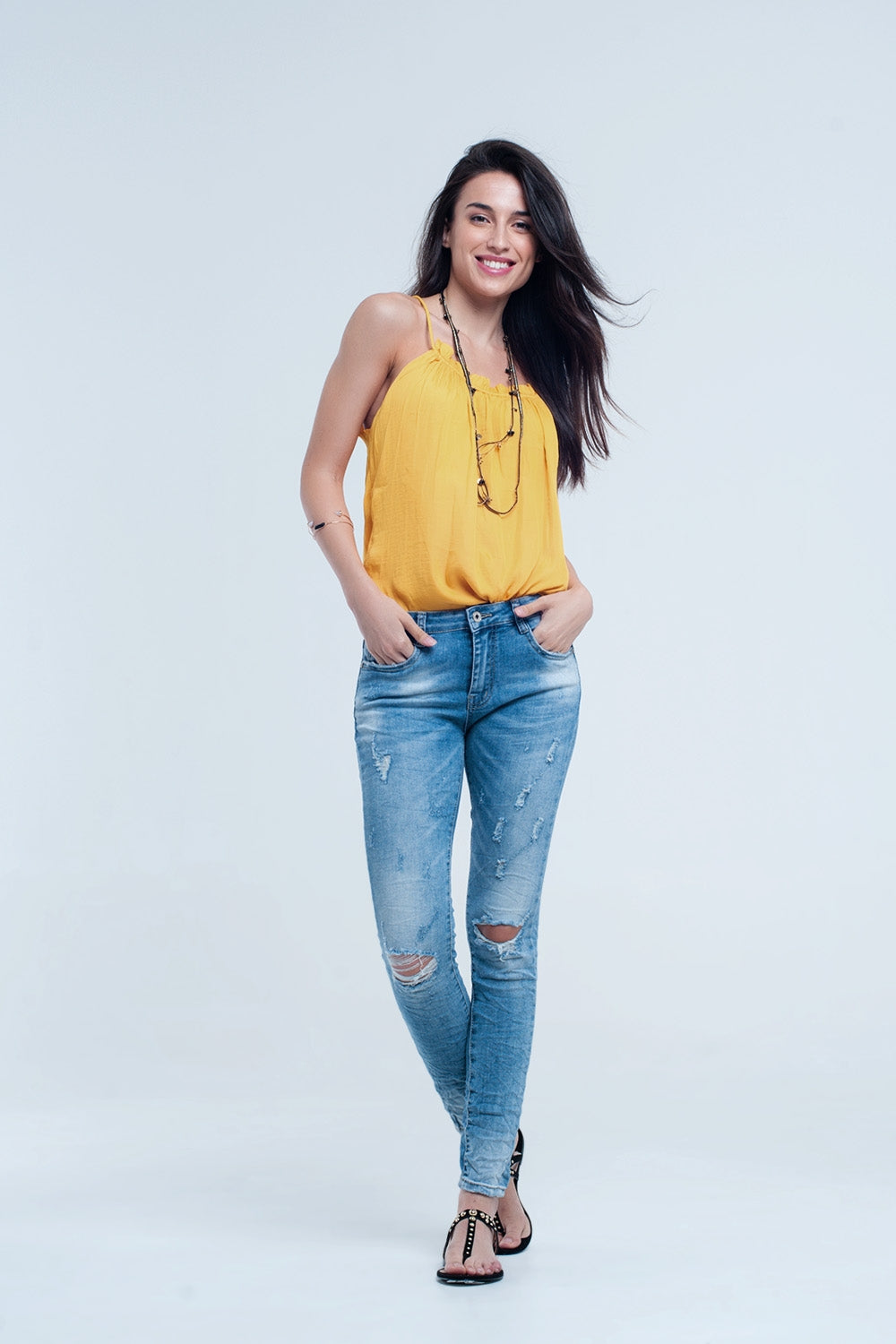 Jeans skinny a metà lavaggio con strappi al ginocchio
