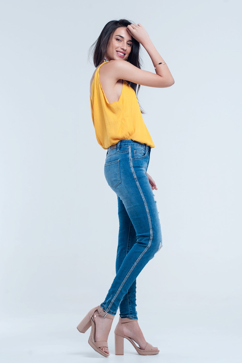Jeans skinny con strappi e glitter