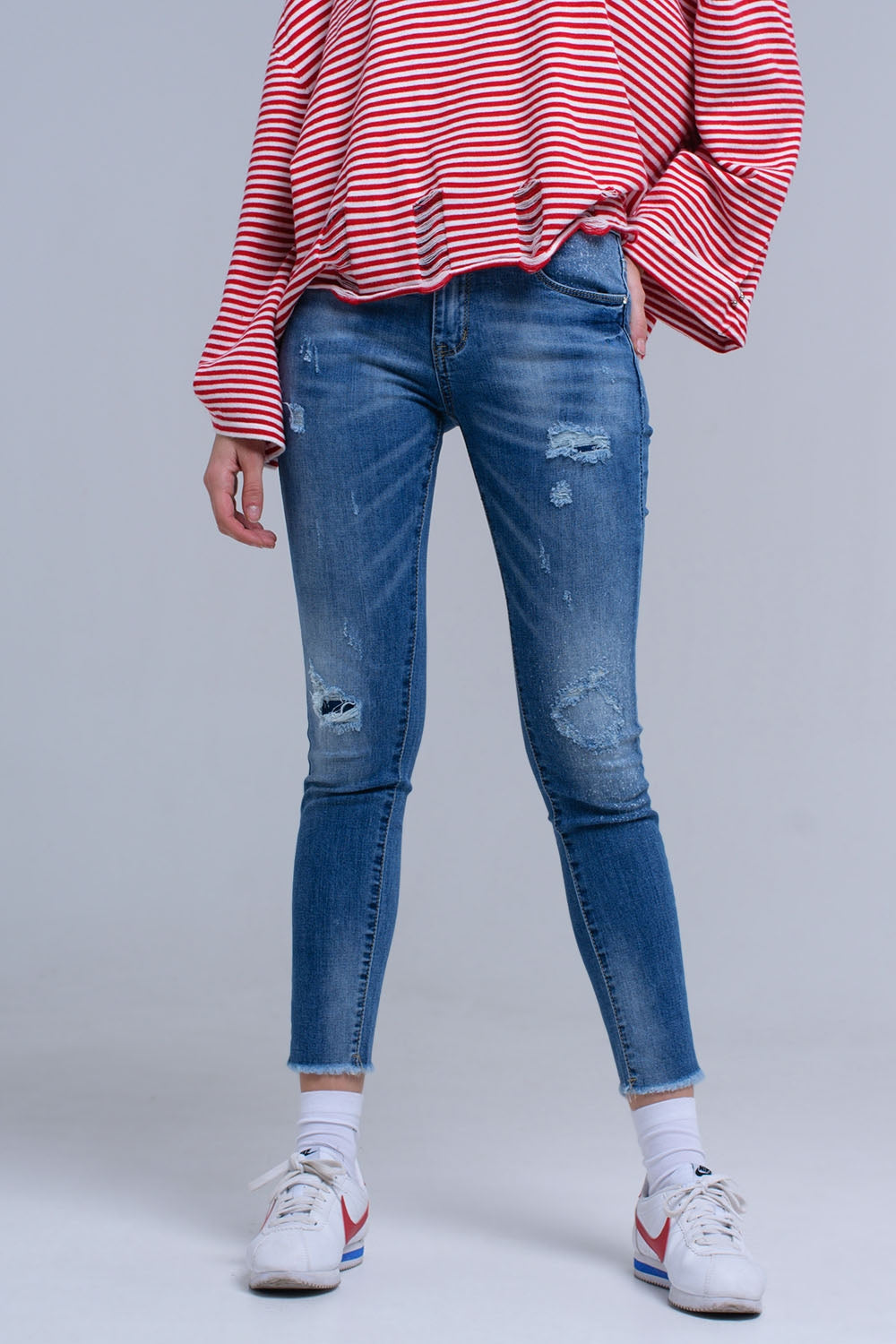 Jeans skinny effetto consumato con frange