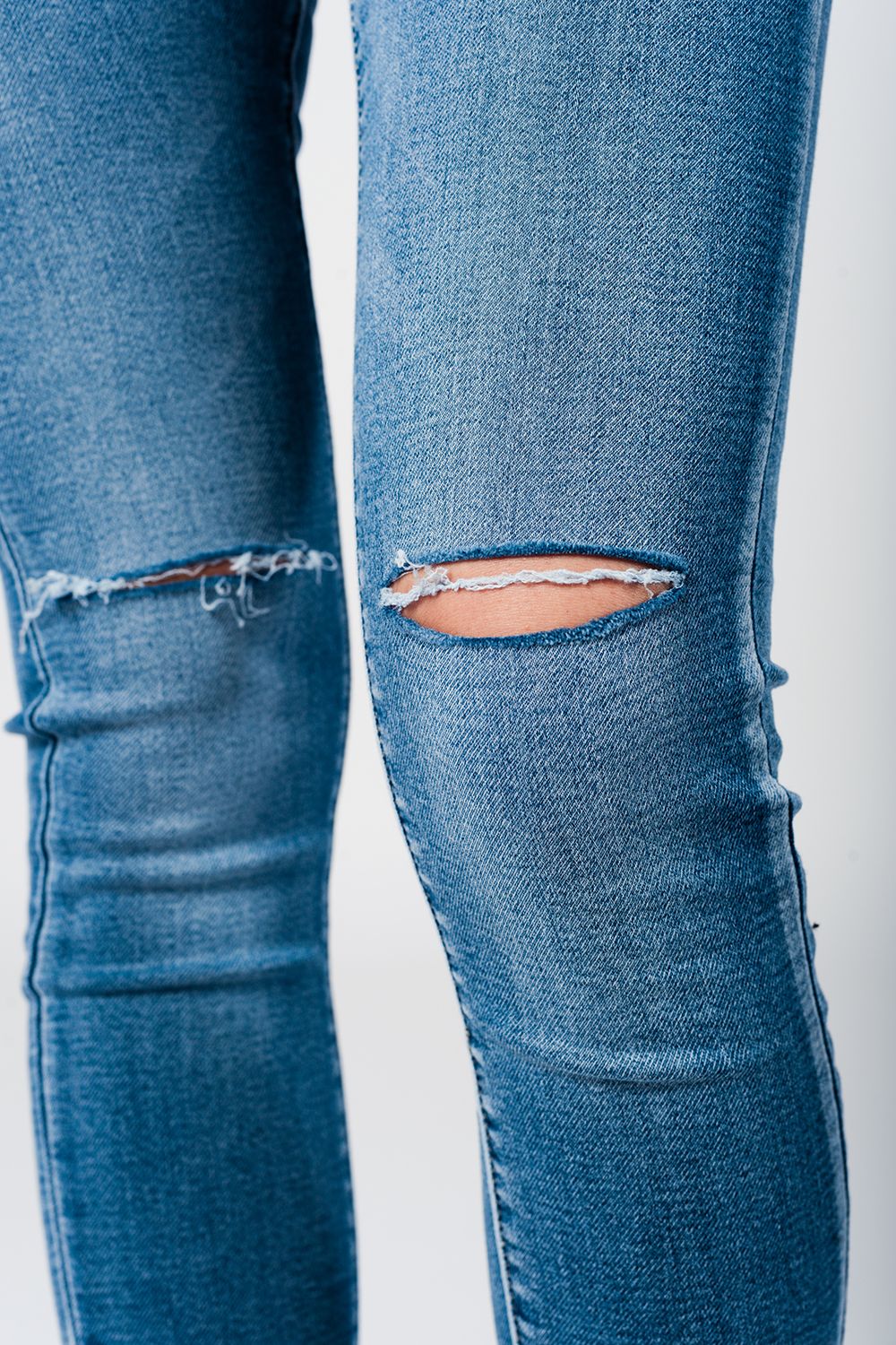 Jeans skinny slavati con strappi e orli sfilacciati