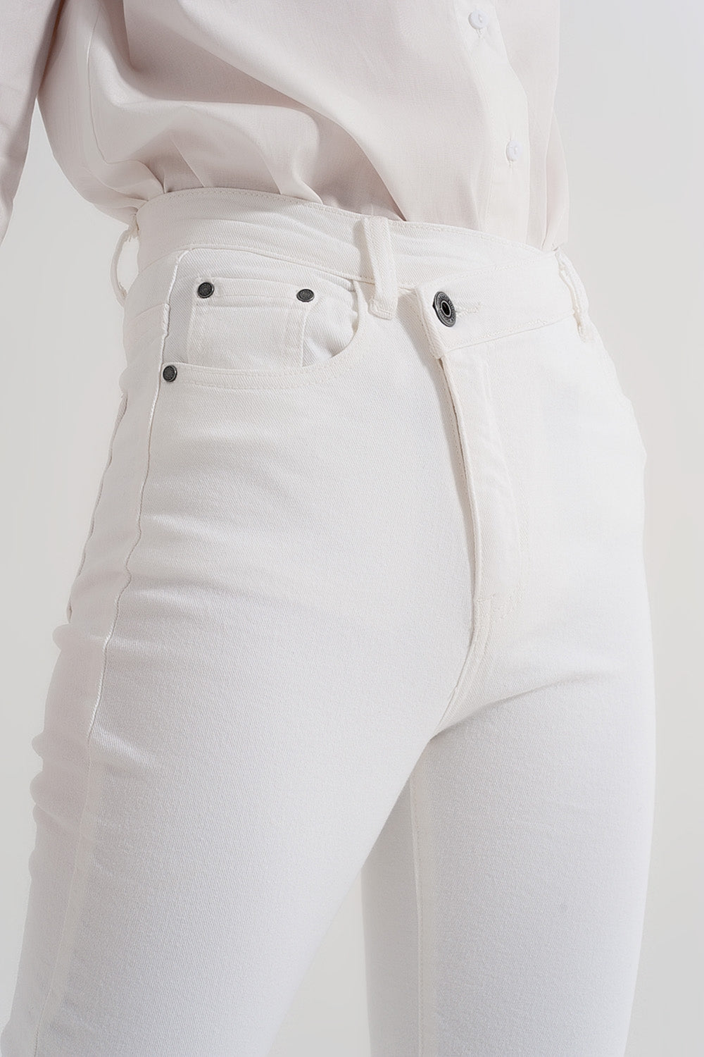 Jeans slim con cerniera asimmetrica e bottone crema