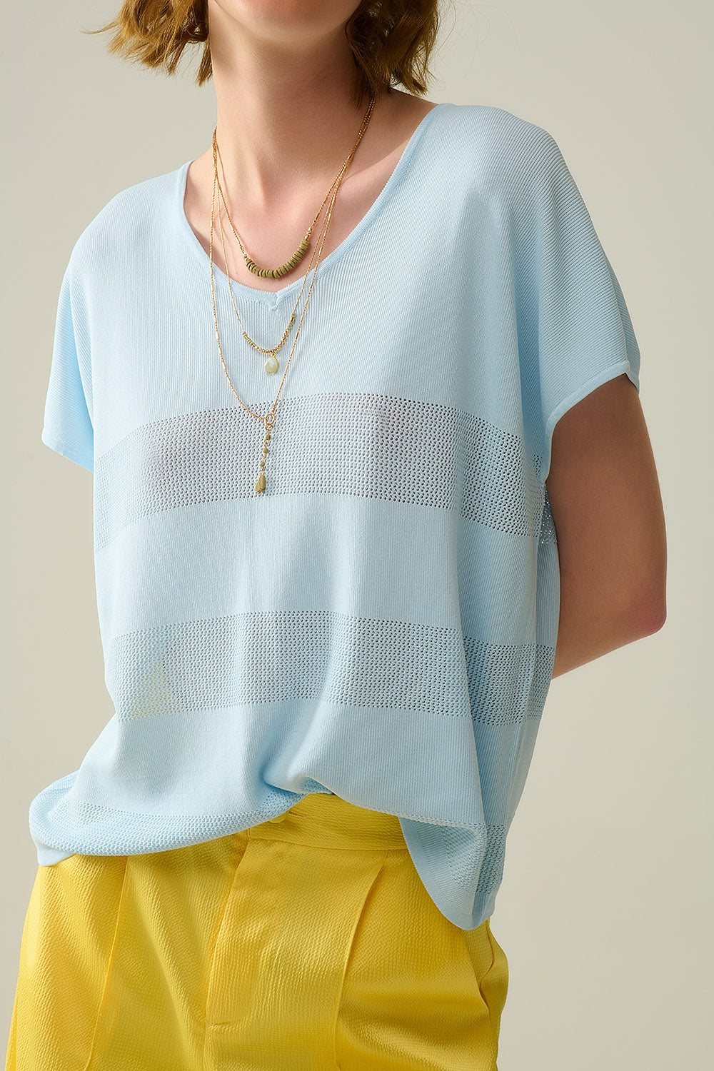 Maglione azzurro con scollo a V e dettaglio a maglia aperta