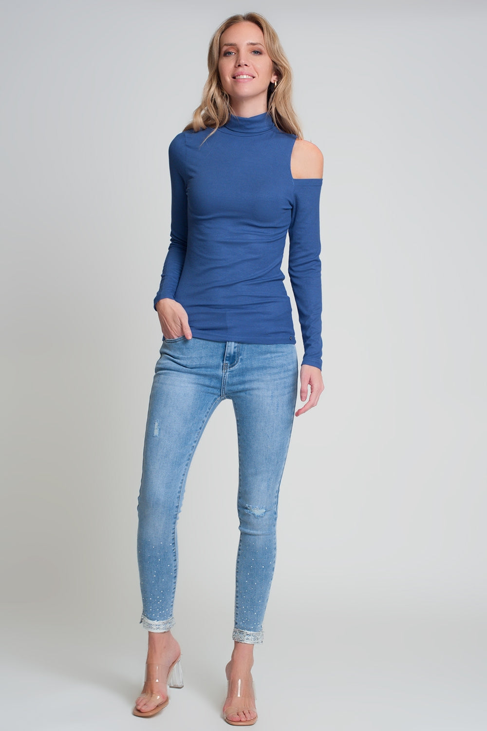 Maglione blu con una spalla scoperta e collo alto
