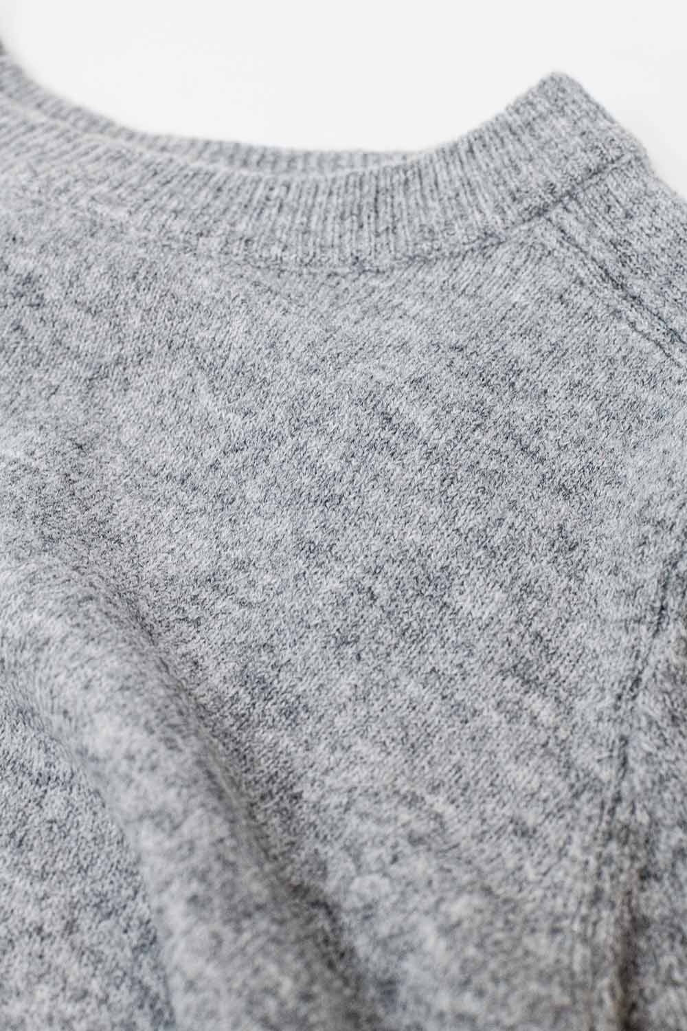 Maglione grigio a girocollo con dettaglio di cucitura sulla manica