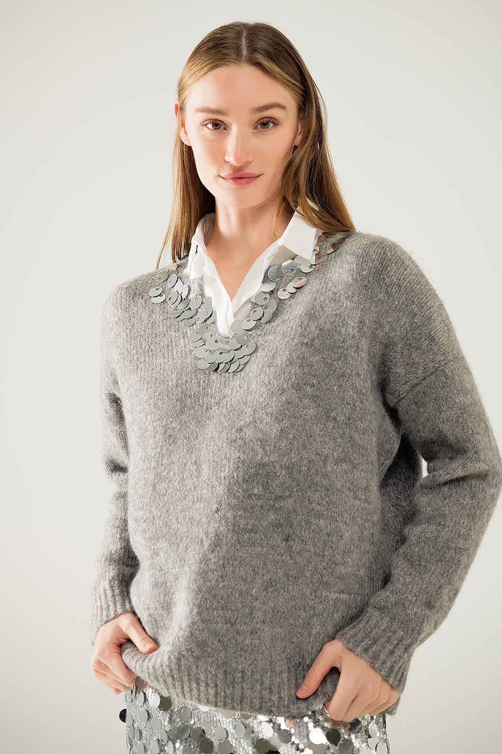 Maglione grigio con scollo a V e dettagli in paillettes