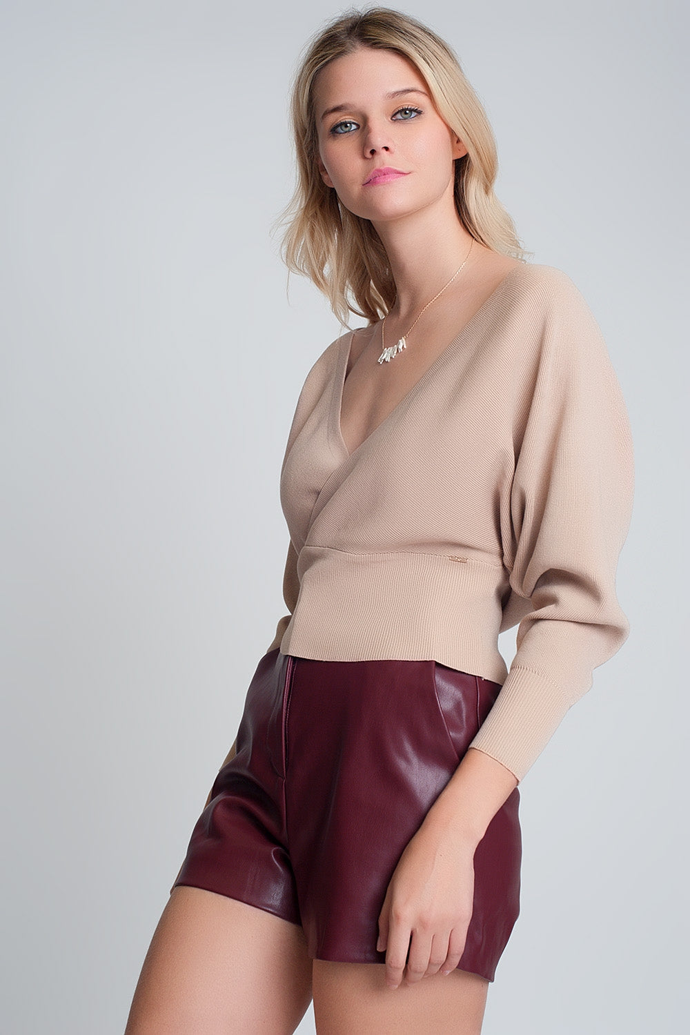 Maglione lavorato a maglia con scollo a V avvolto in beige
