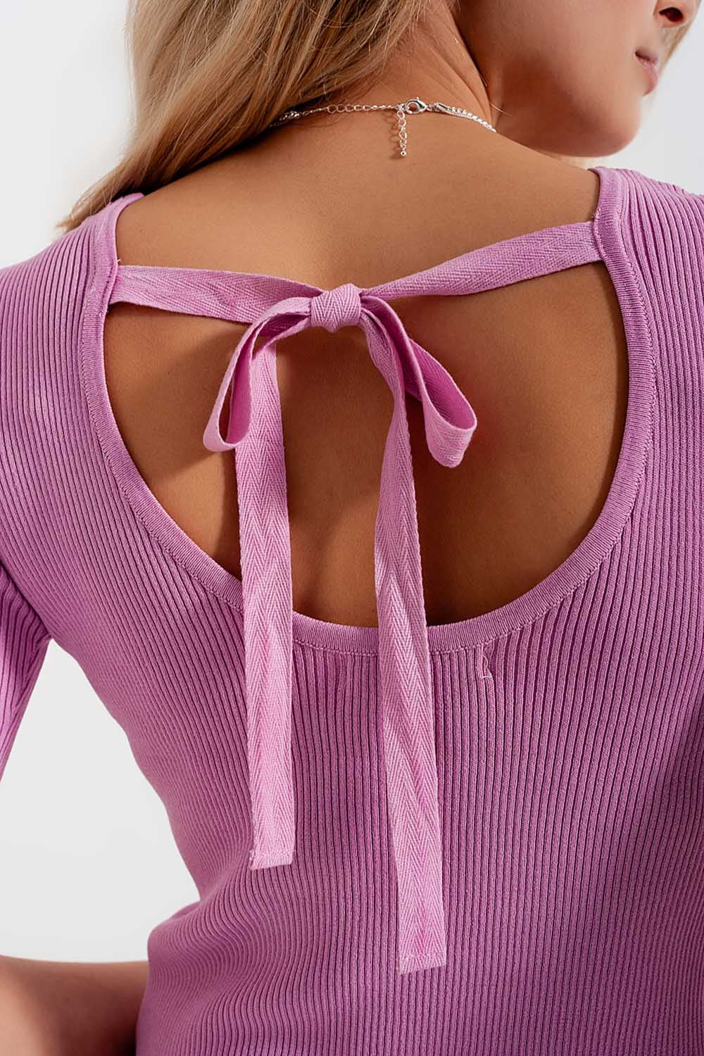 Maglione rosa lavorato con nodo sul retro