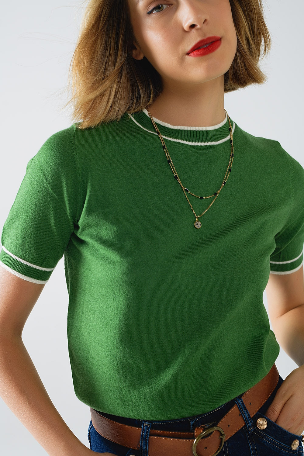 Maglione verde a maniche corte con dettaglio di linee bianche