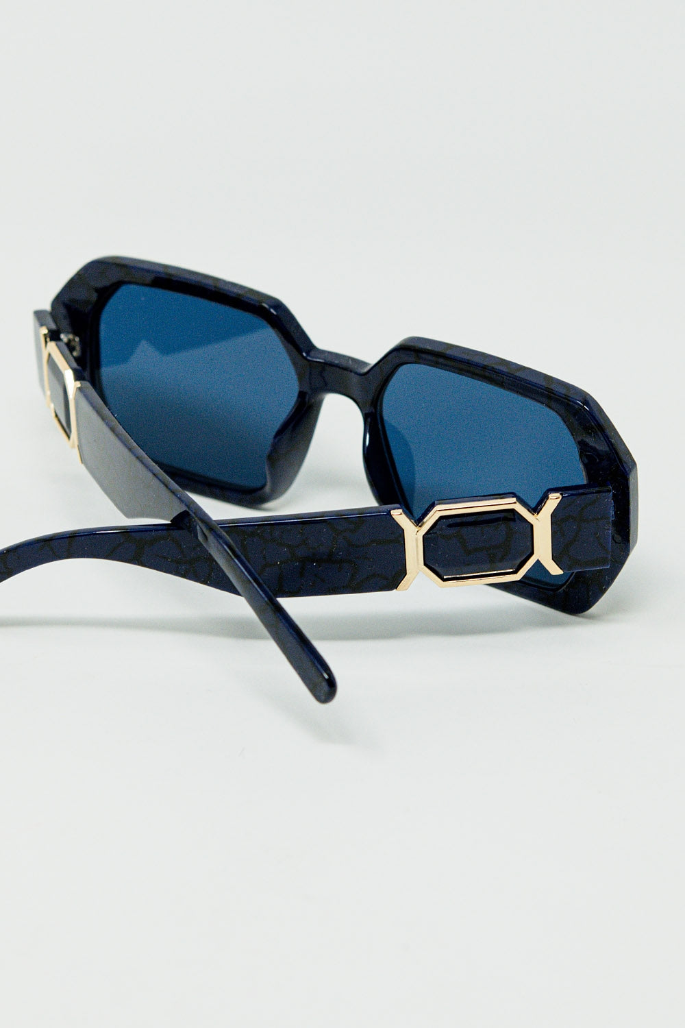 Occhiali da sole a forma di diamante in nero con lenti blu intenso
