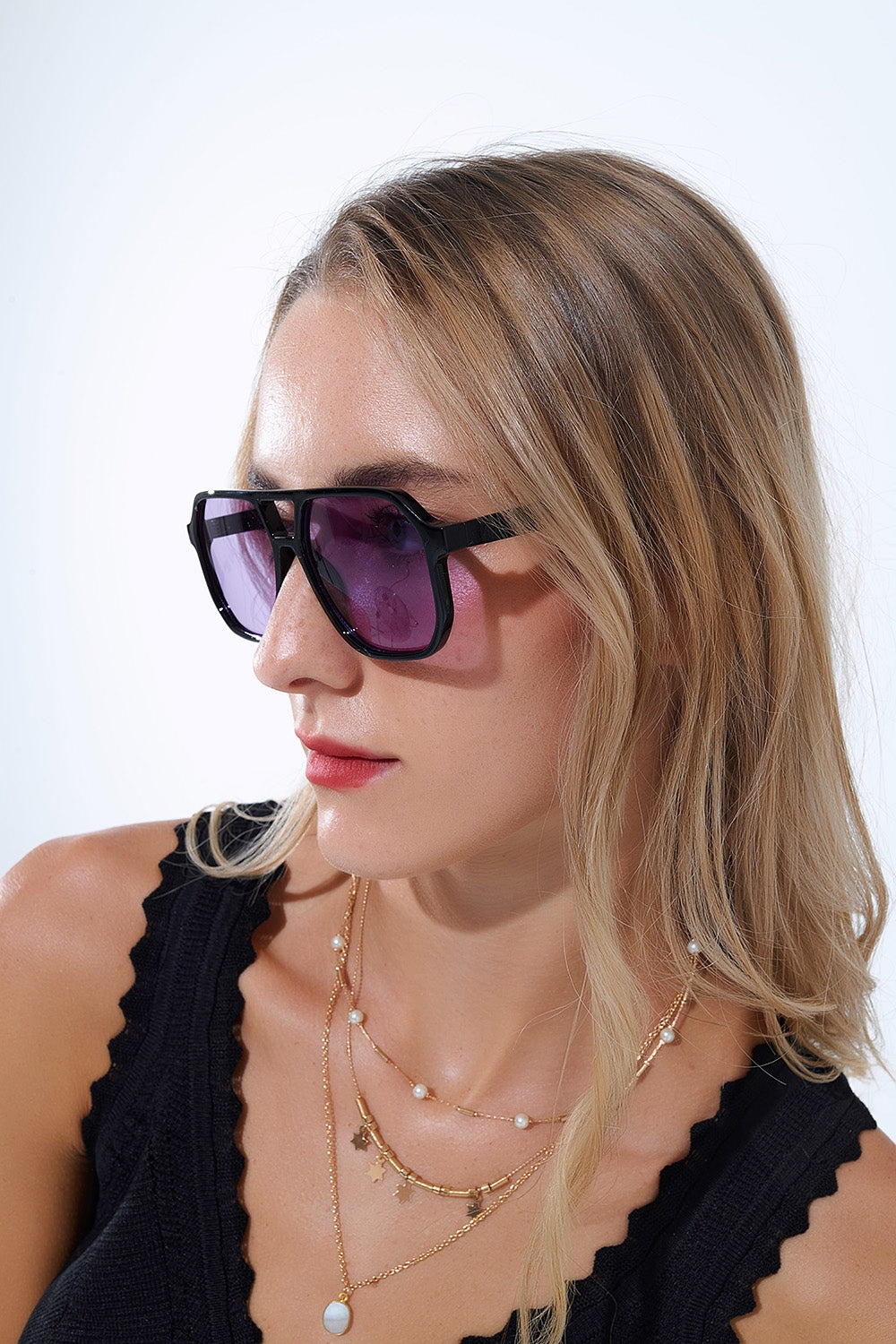 Occhiali da sole in stile retrò con montatura nera e lenti viola