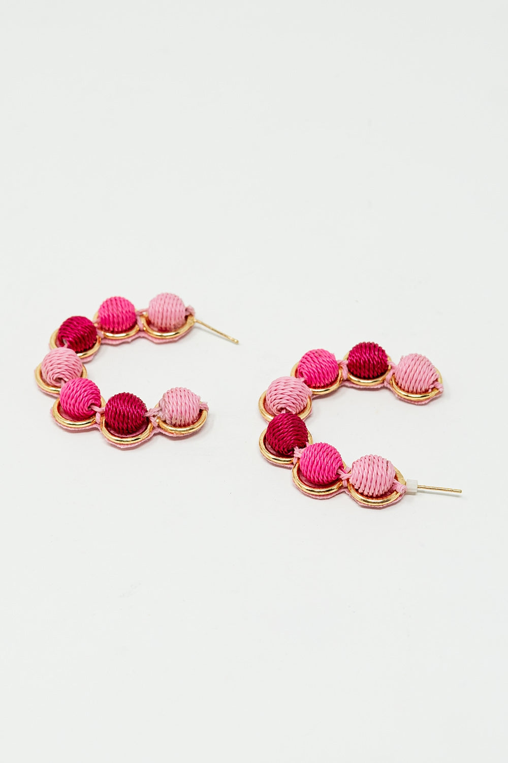Orecchino a cerchio in oro con sfere di lana in rosa e fucsia