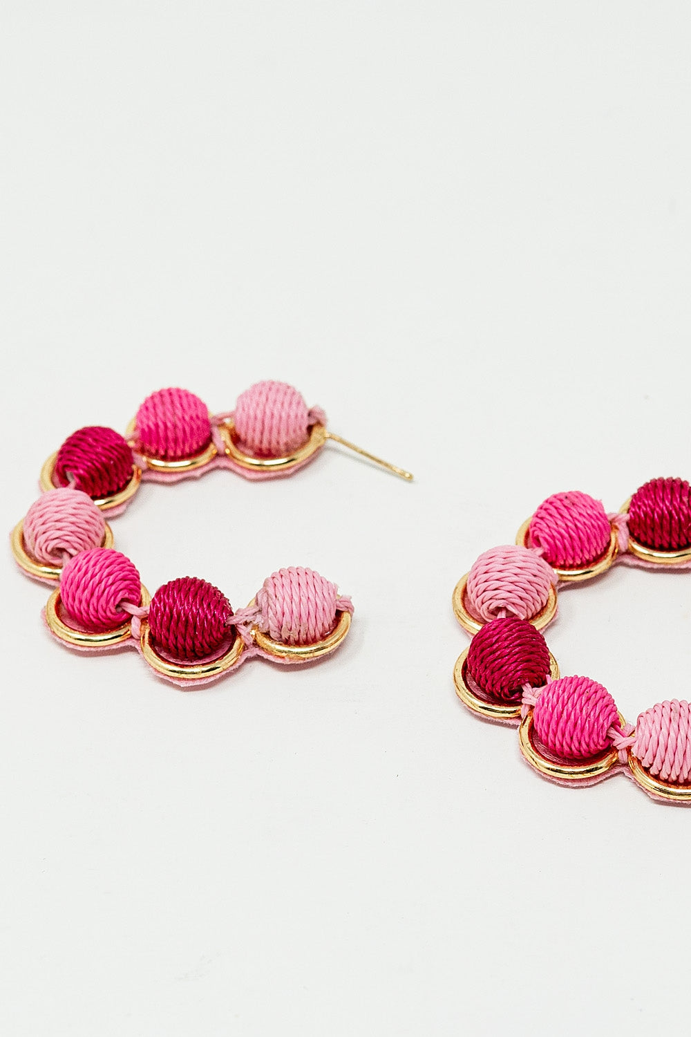 Orecchino a cerchio in oro con sfere di lana in rosa e fucsia
