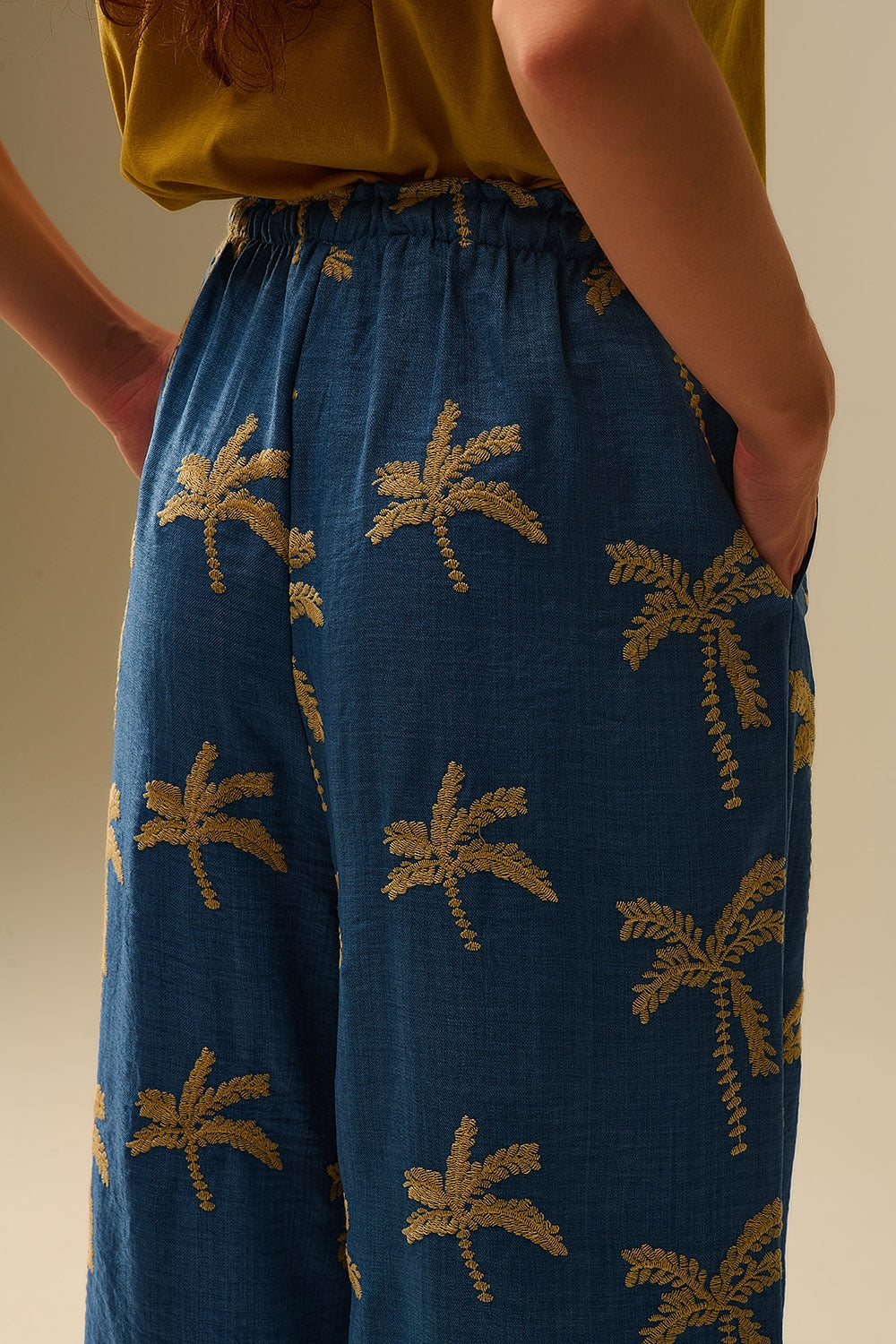 Pantaloni a gamba larga blu con ricamo di palme beige