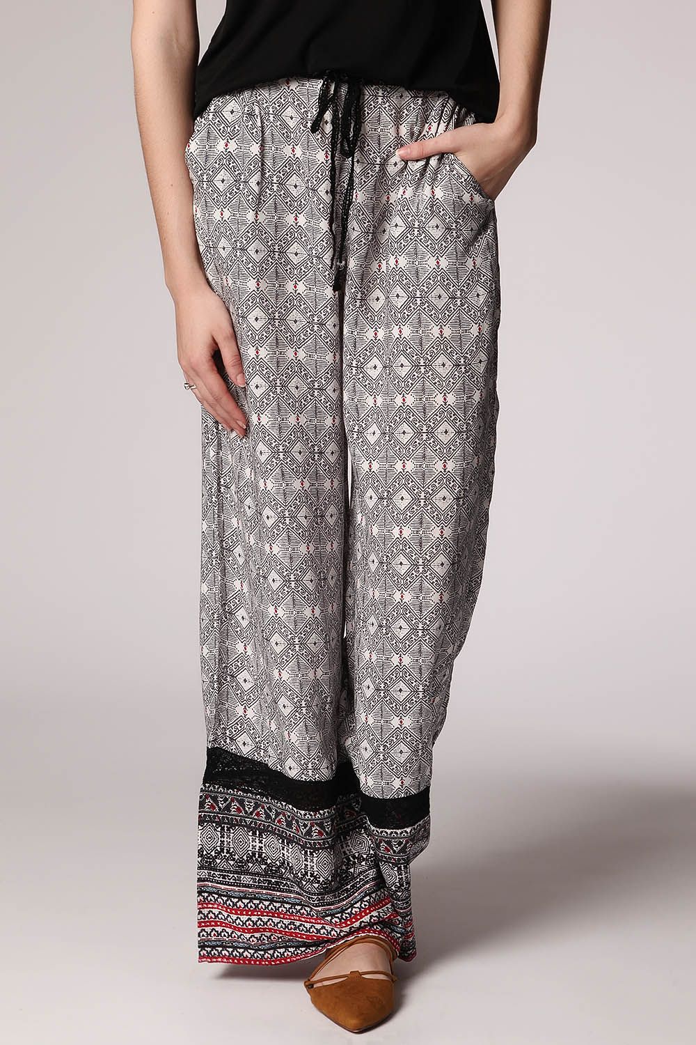 Pantaloni con fondo ampio nero con stampa etnica e inserto in pizzo