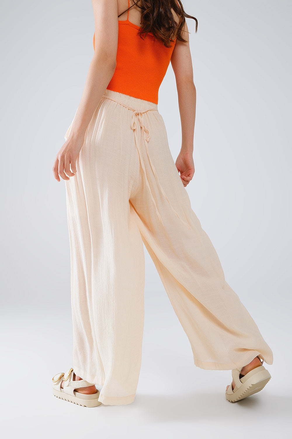 Pantaloni stile palazzo beige con tasche laterali e banda spessa in vita