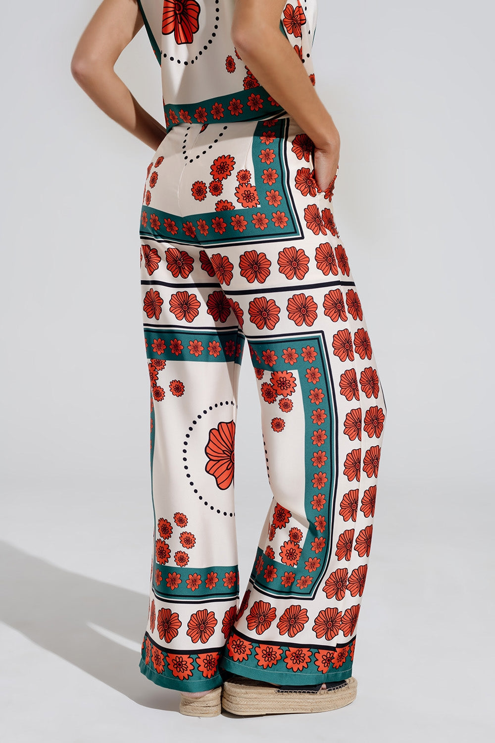 Pantaloni svasati color crema con design floreale