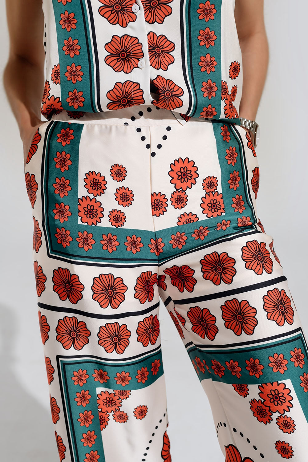 Pantaloni svasati color crema con design floreale