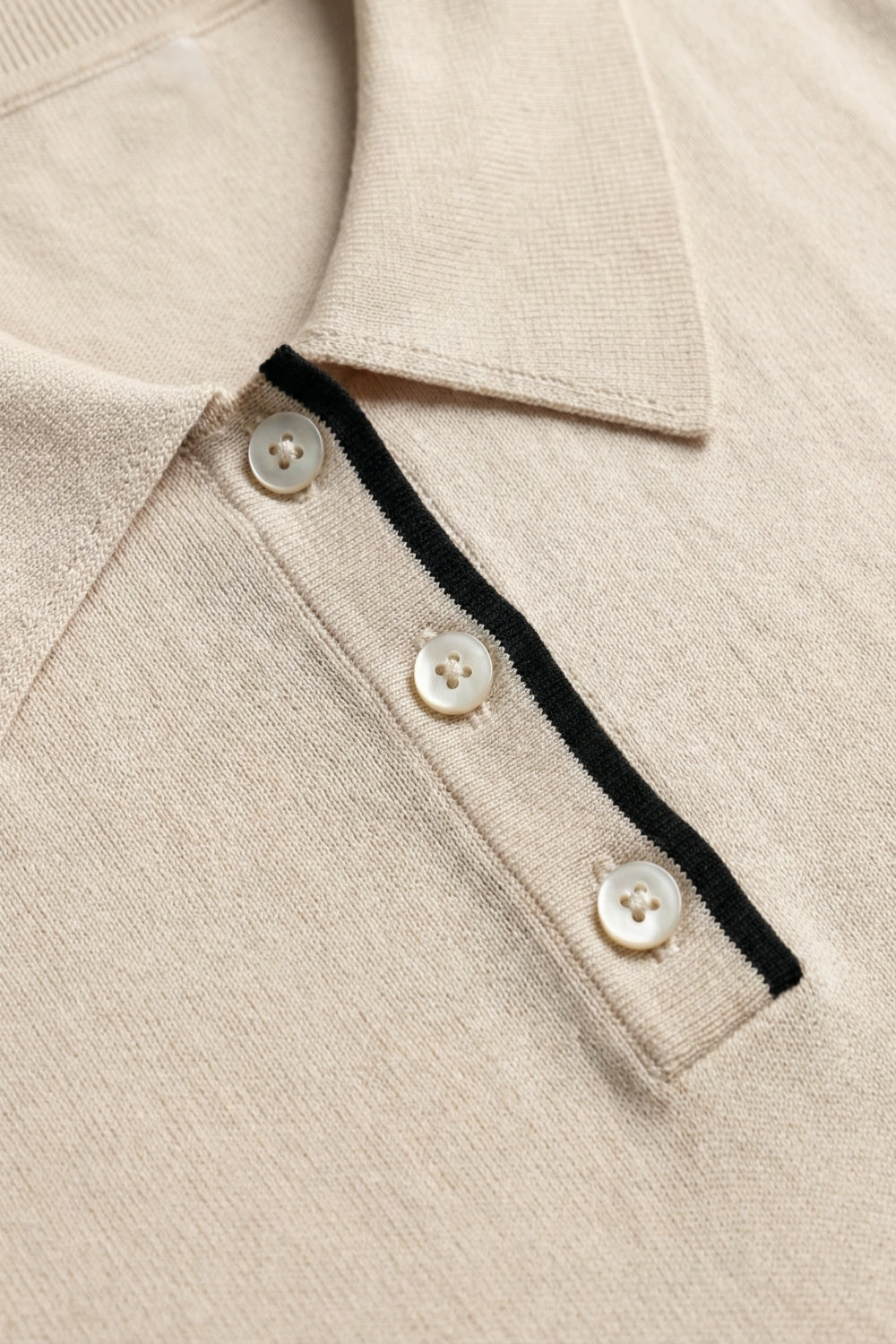 Polo in maglia beige con dettagli in nero