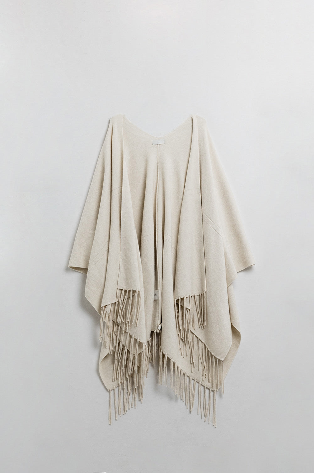 Poncho in morbida maglia beige con frange