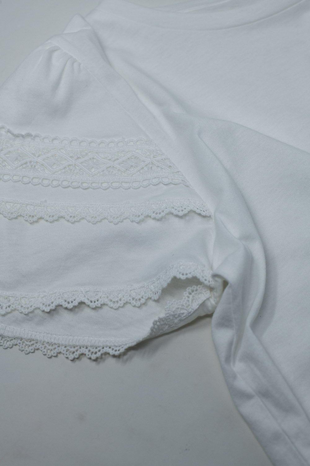 T-shirt bianca con maniche arricciate a doppio strato.