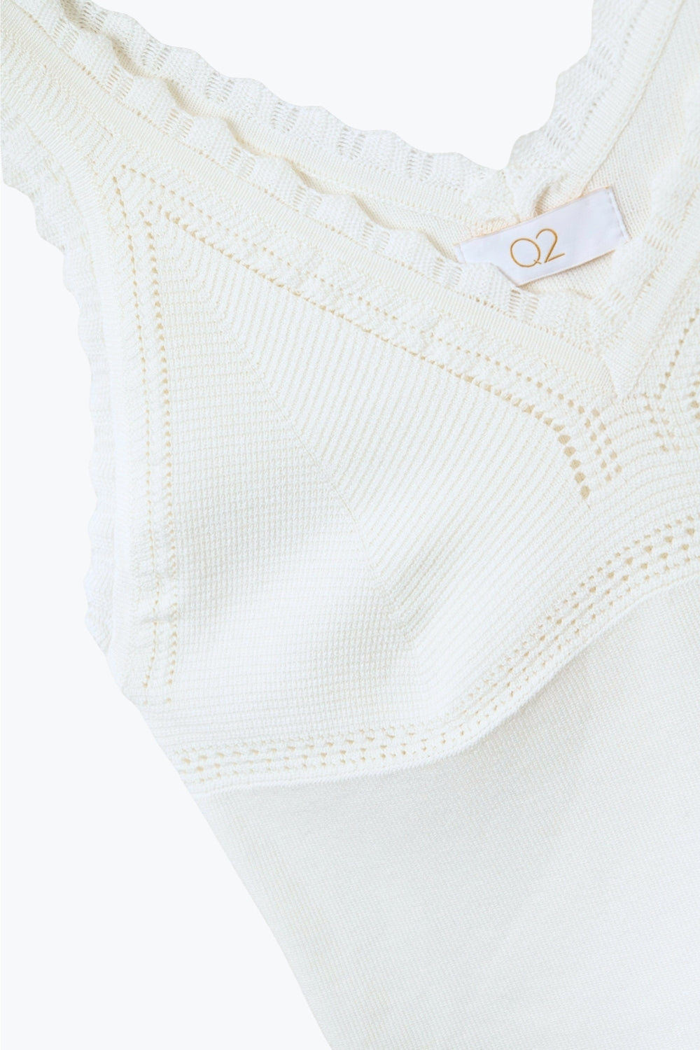 Top in maglia bianca con scollo a V e bordi smerlati