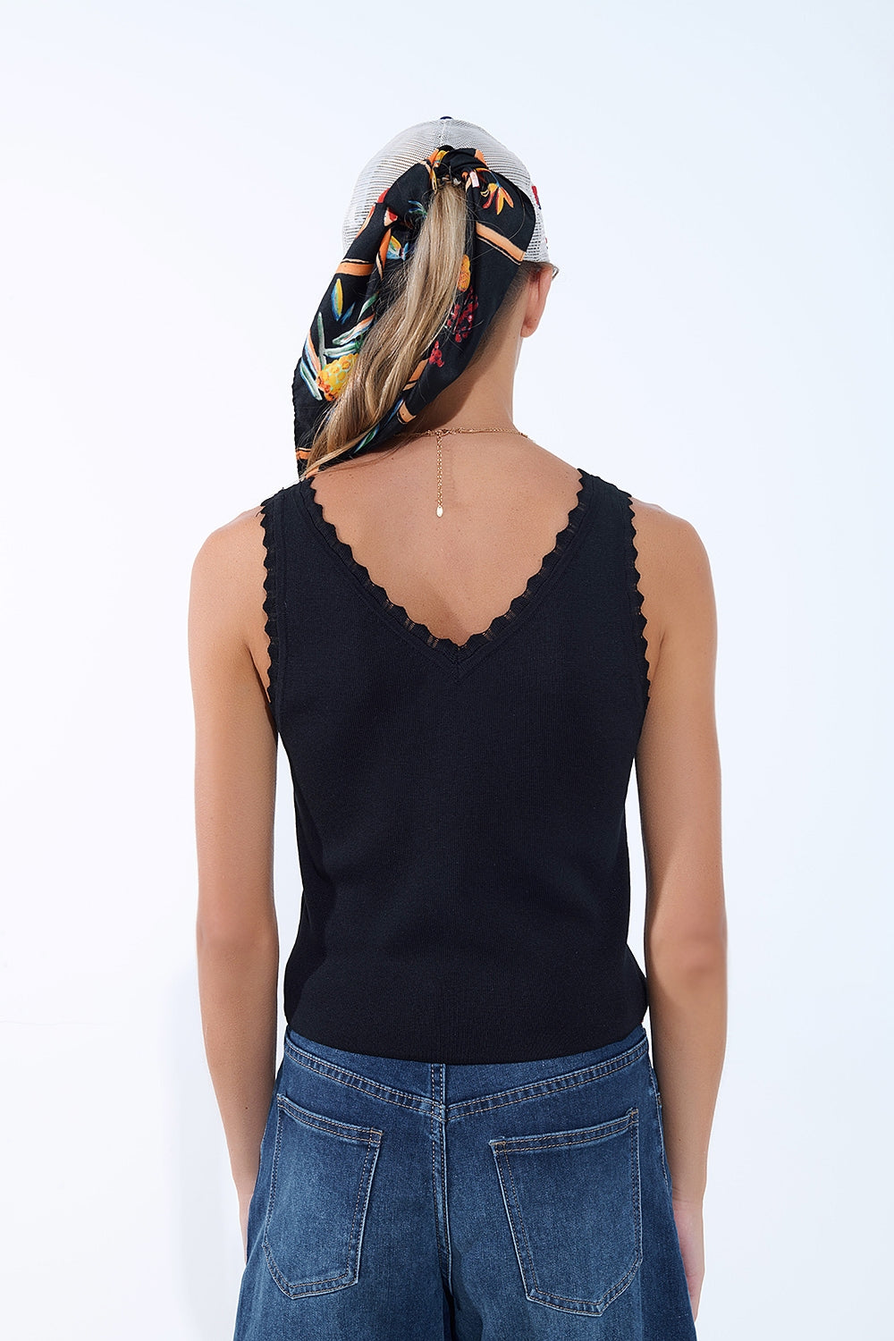 Top nero in maglia con scollo a V e bordi smerlati