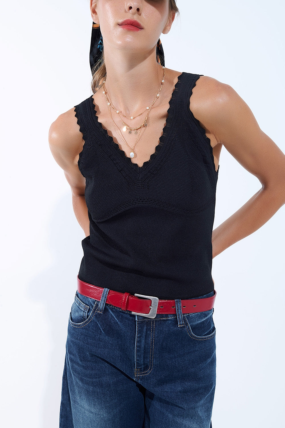 Top nero in maglia con scollo a V e bordi smerlati