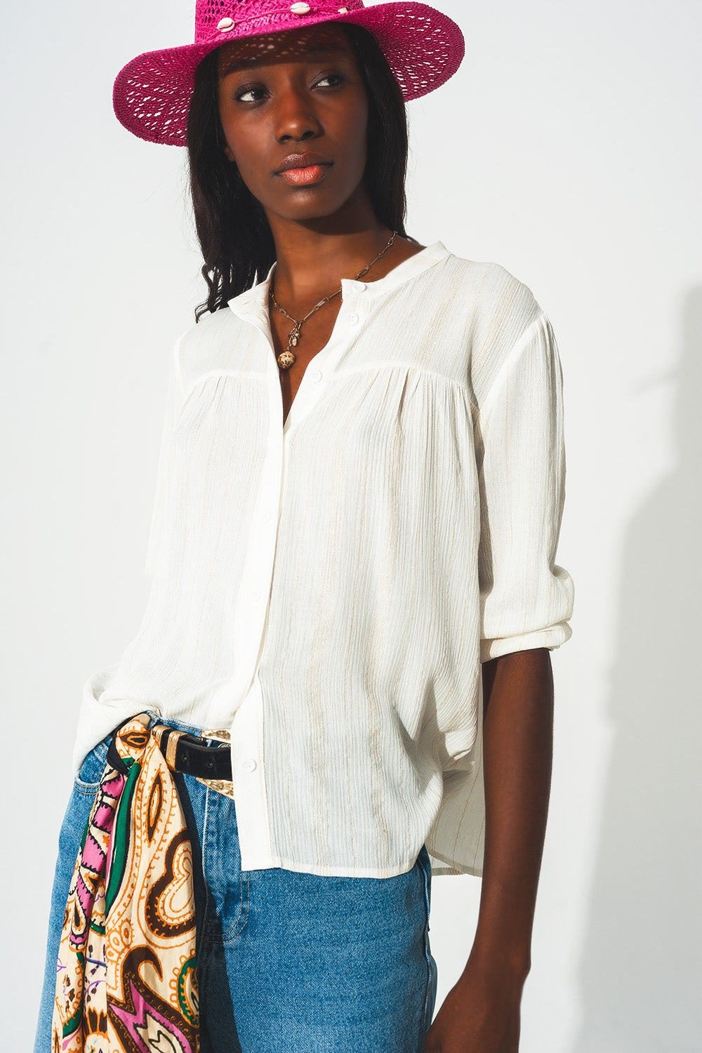 Q2 Blusa crema a righe dorate con collo serafino