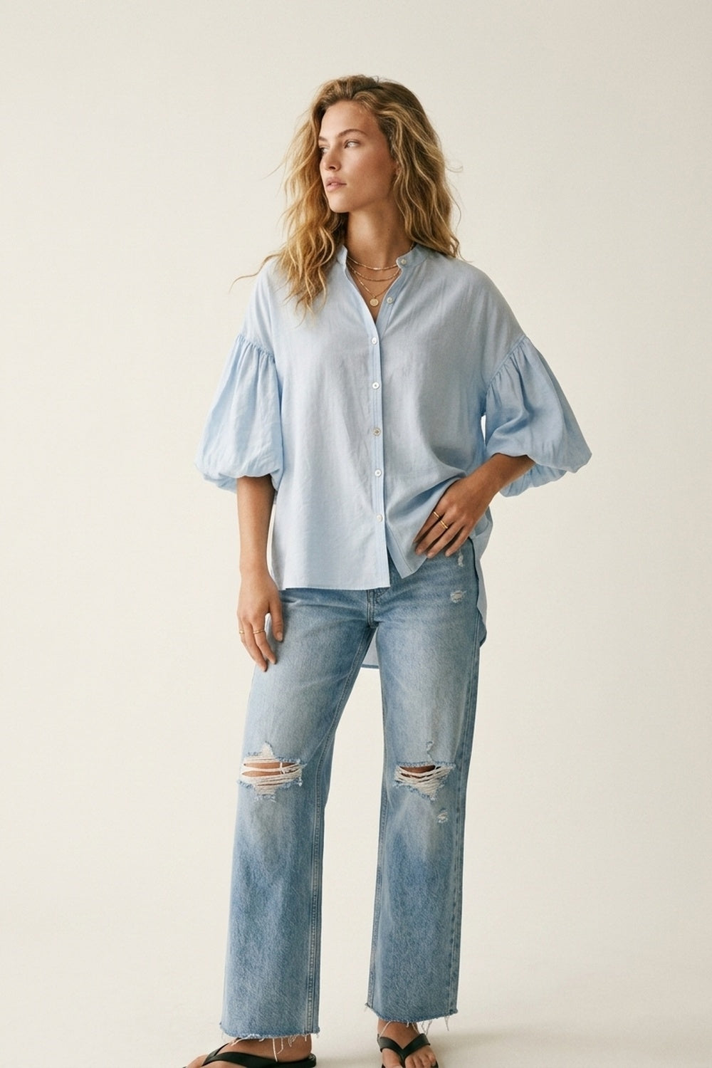 Q2 Blusa azzurra con maniche a sbuffo e bottoni sul retro